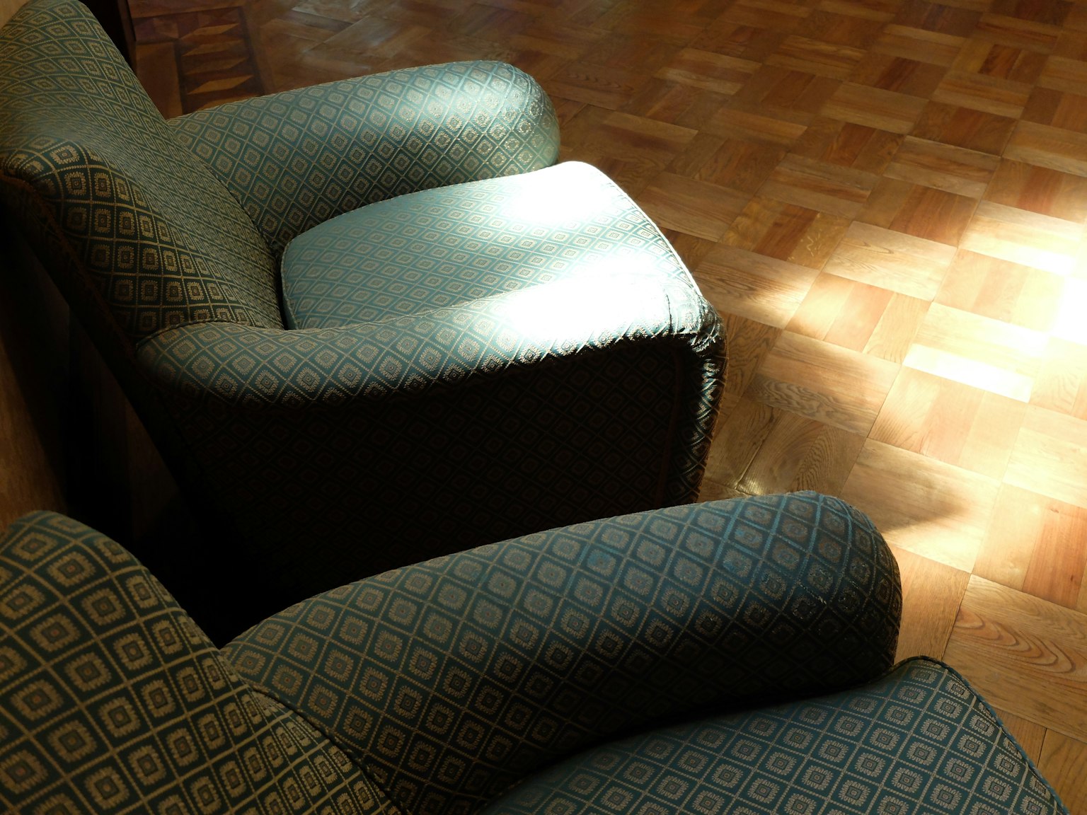 Two patterned armchairs with light shining on them