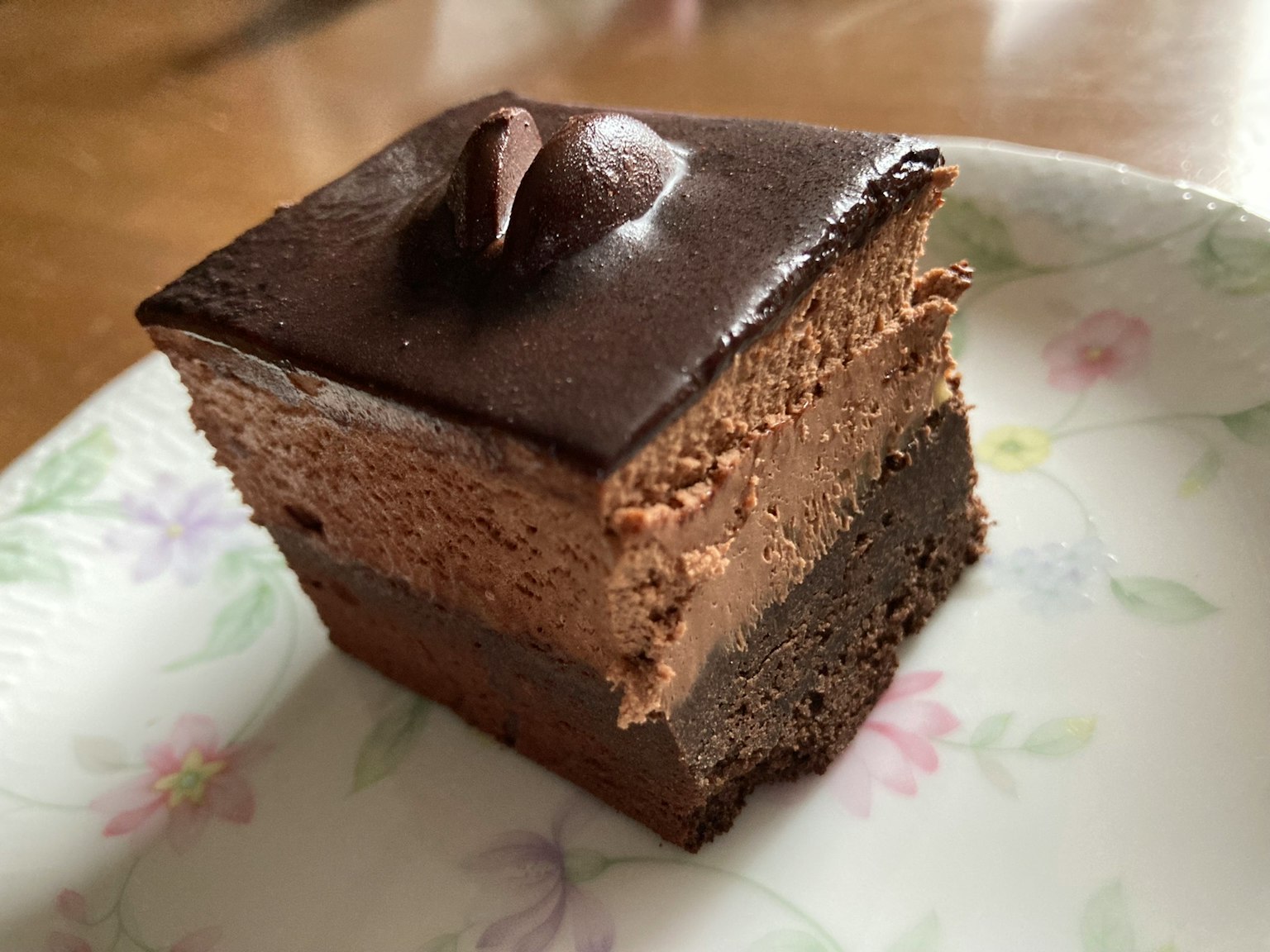 A slice of chocolate cake on a floral plate