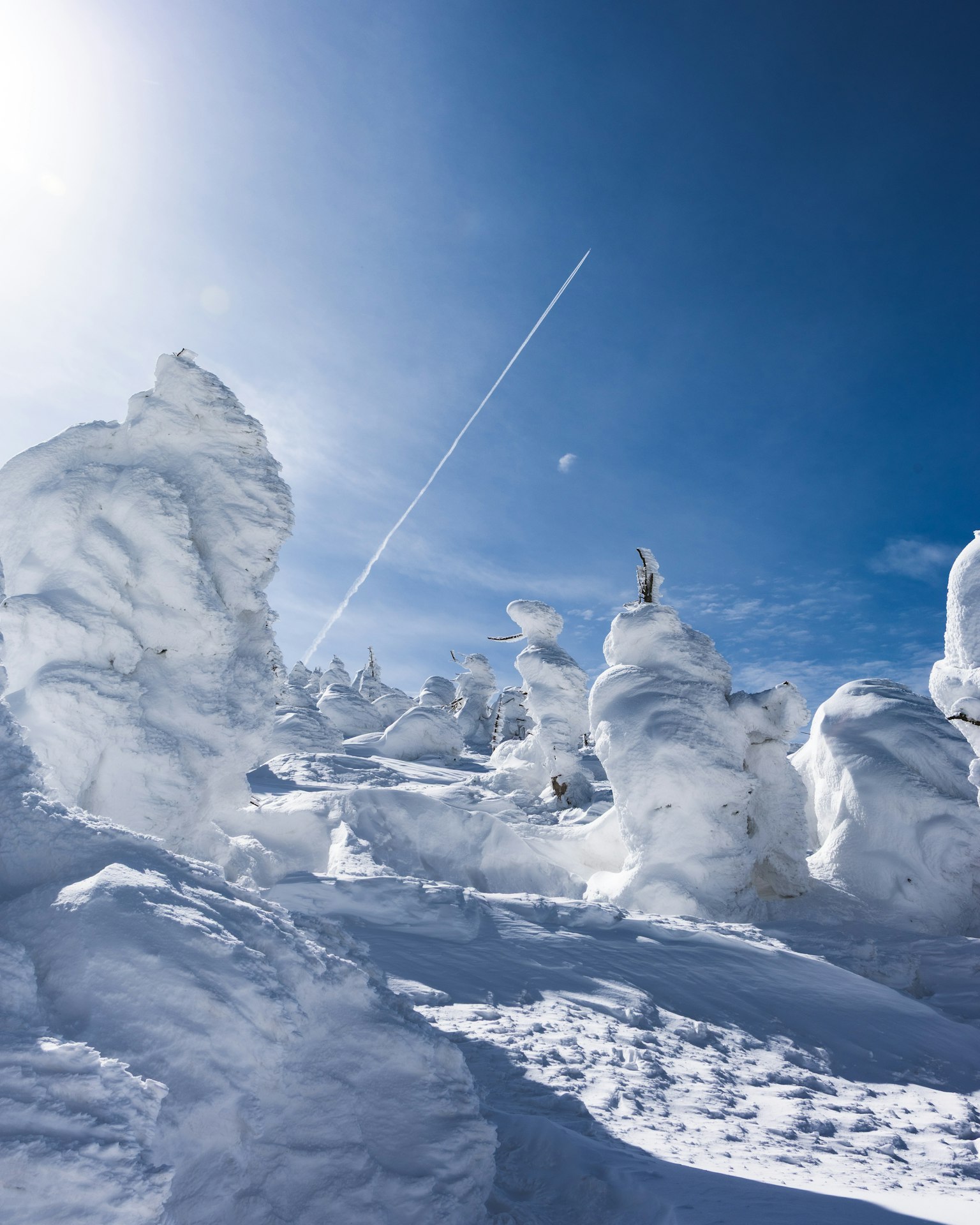 雪に覆われた山の風景と青い空の下にある雪の彫刻