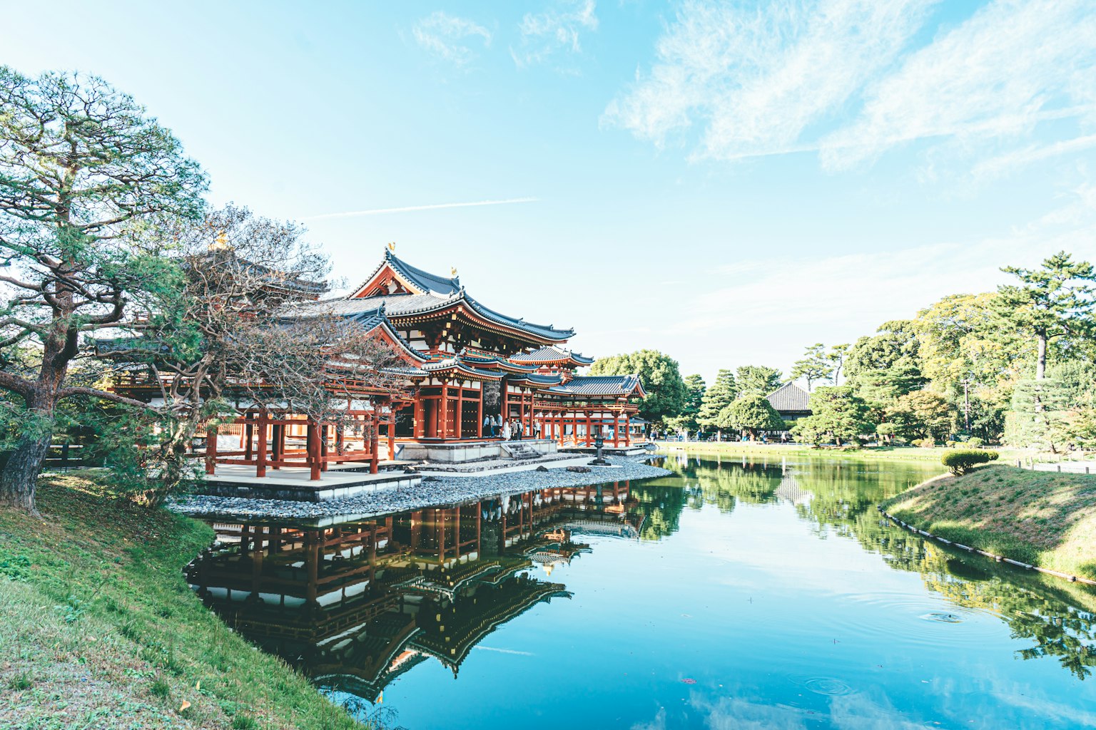 Traditionelles japanisches Gebäude an einem ruhigen Teich, umgeben von Bäumen