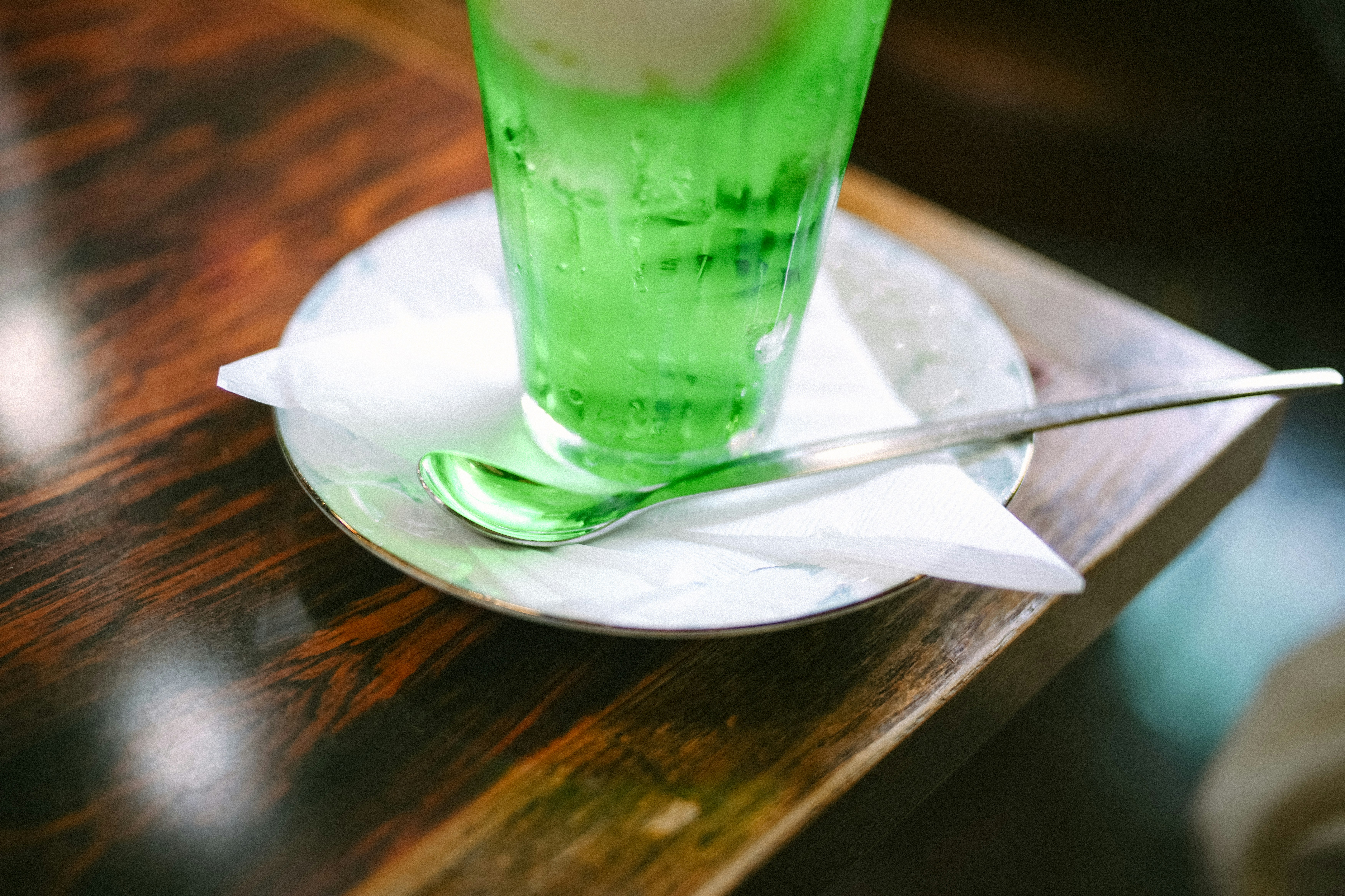 木桌上綠色飲品倒入玻璃杯的瞬間