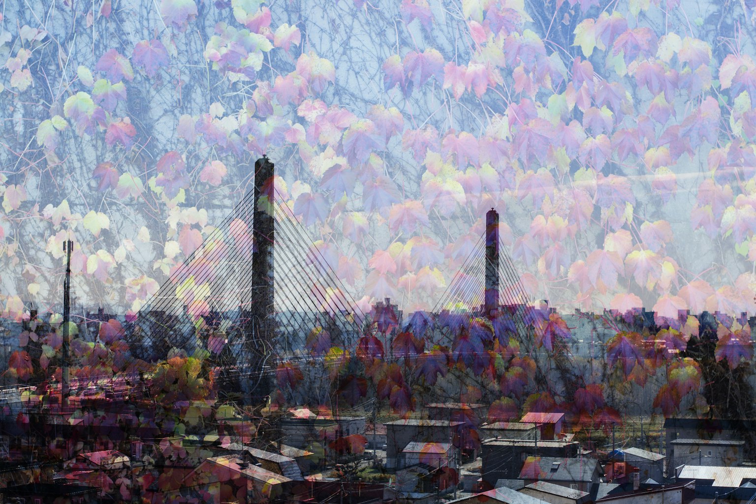 Paesaggio urbano con alte torri e camini sotto un cielo pieno di nuvole colorate