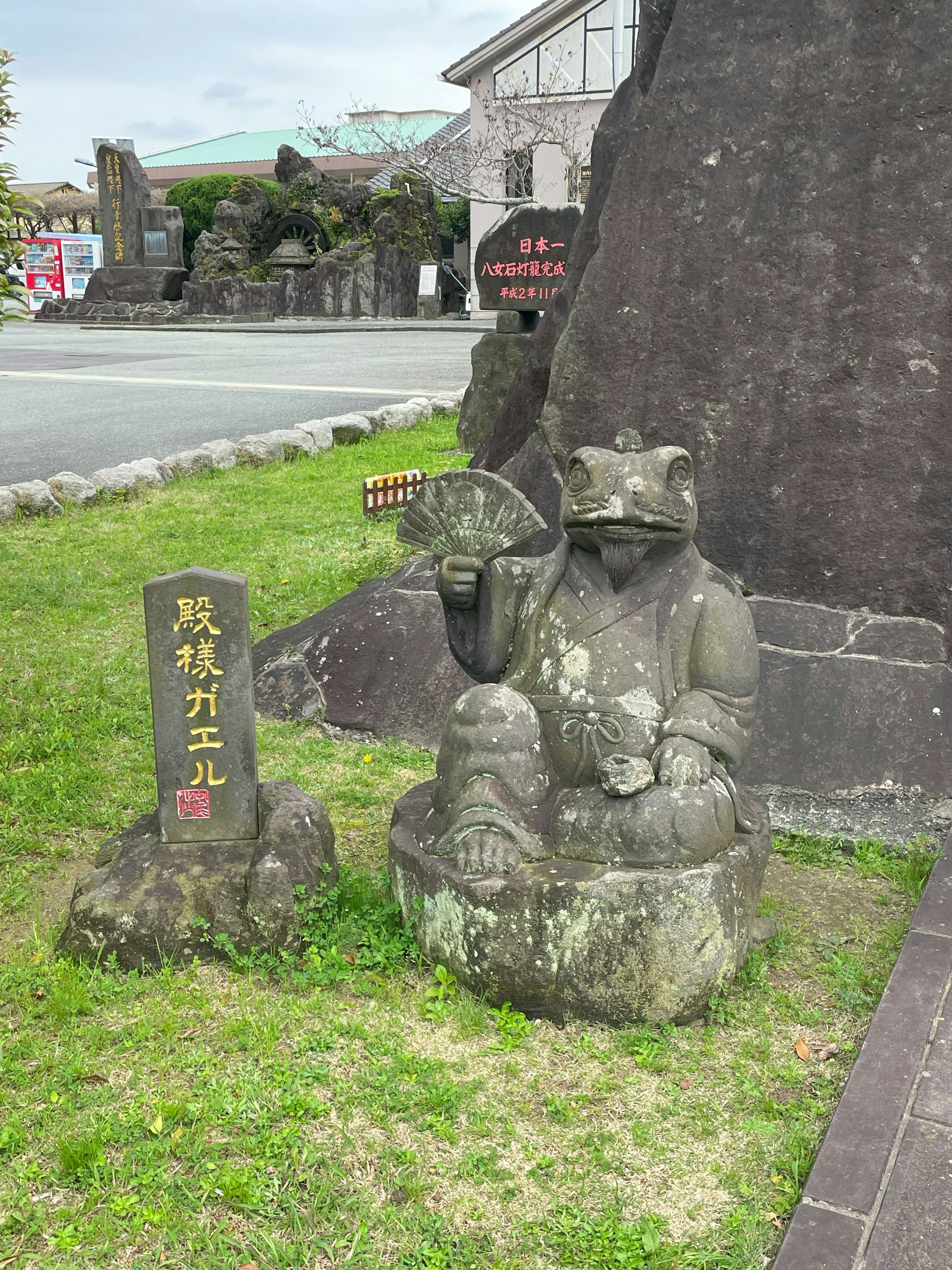 庭園の石像と看板のある屋外の景観