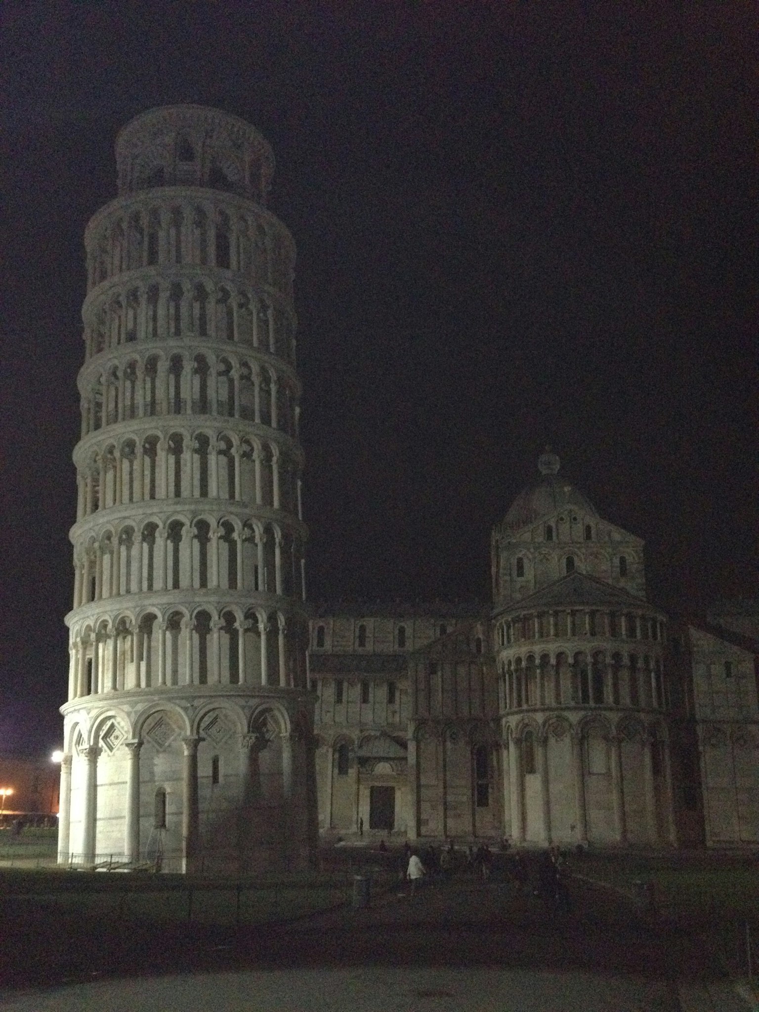Leaning Tower of Pisa at night with surrounding architecture