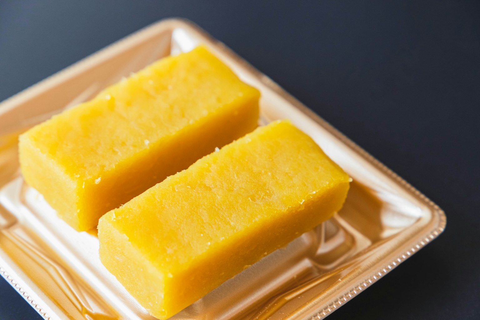 Due dessert gialli brillanti su un piatto dorato