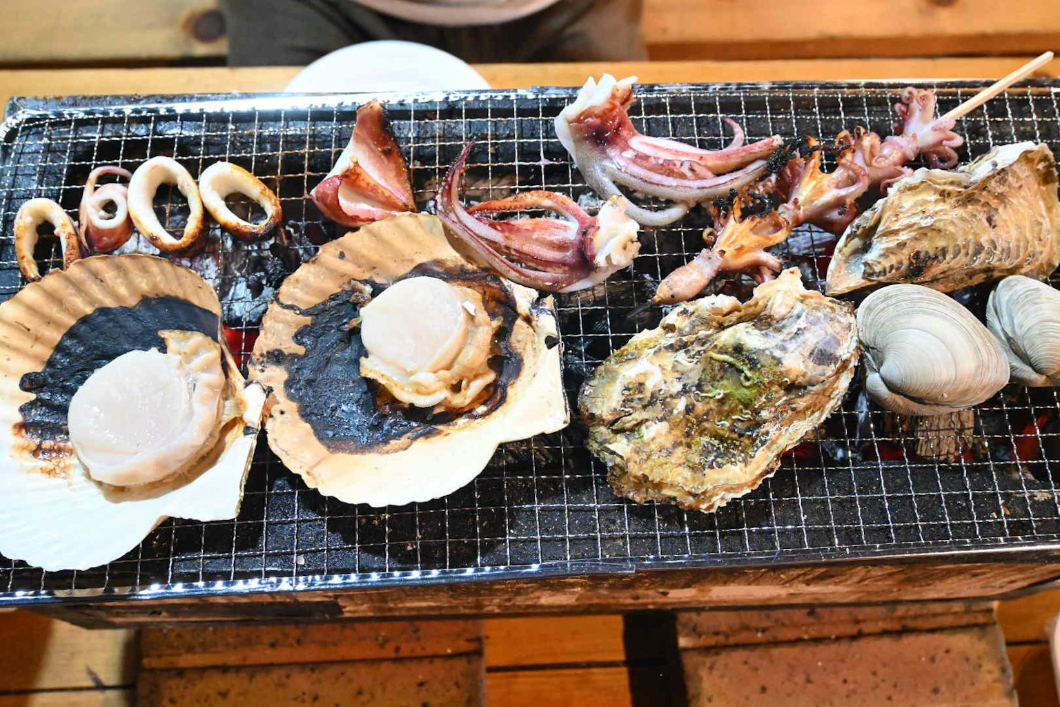 Una variedad de mariscos frescos asándose en una parrilla