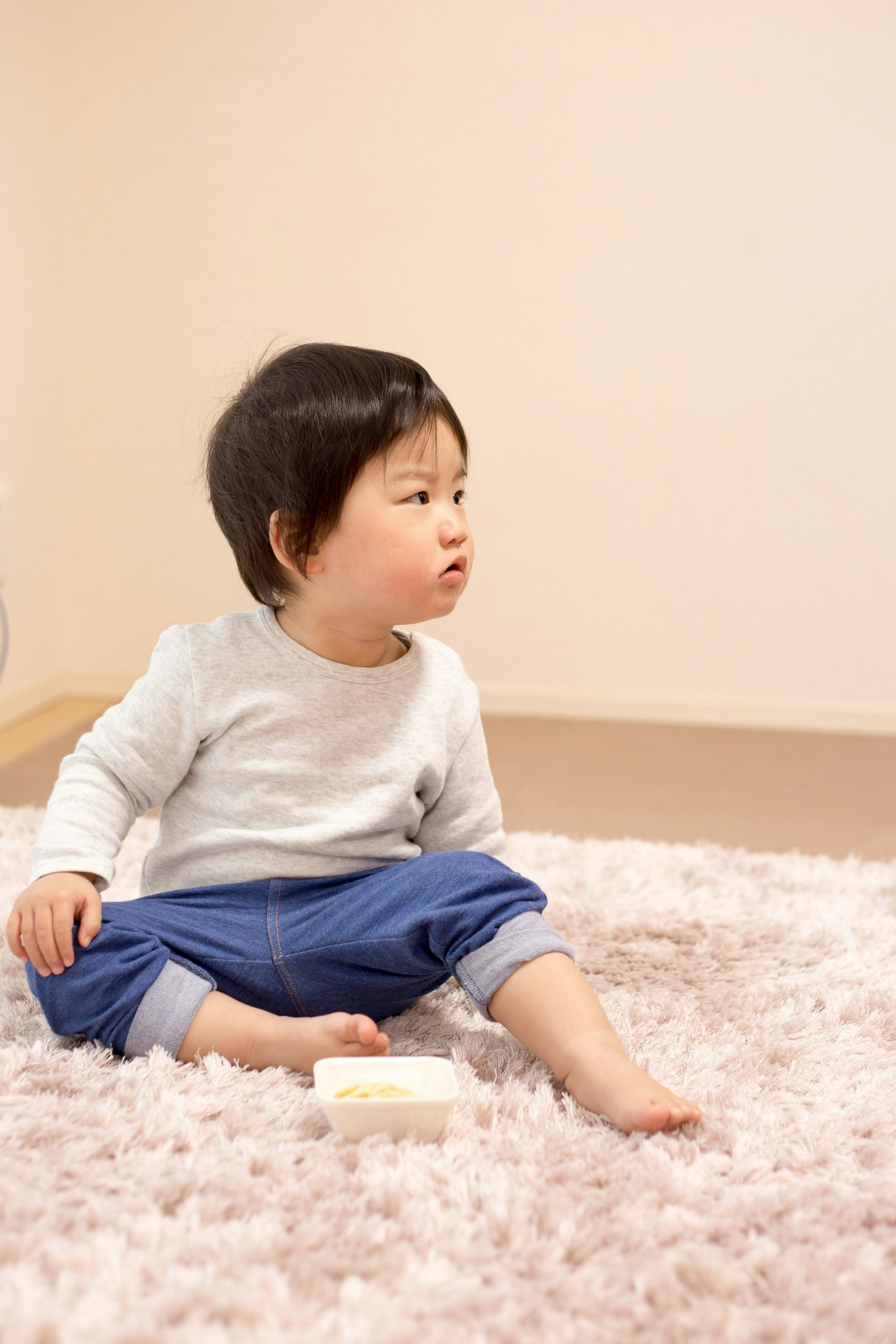 室內坐在毯子上的幼兒
