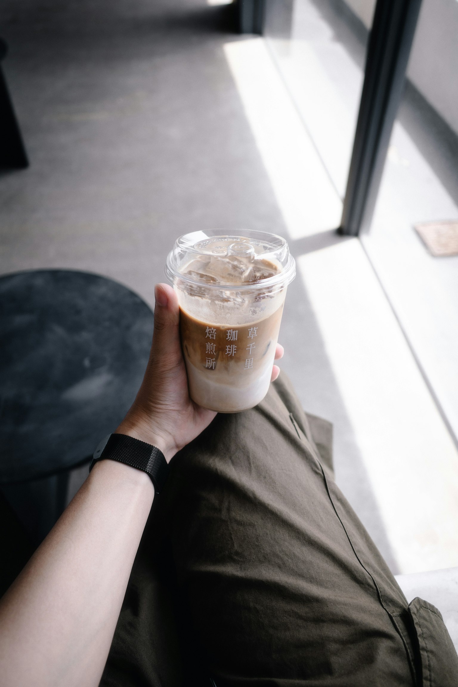 Một bàn tay cầm cà phê đá trong quán cà phê