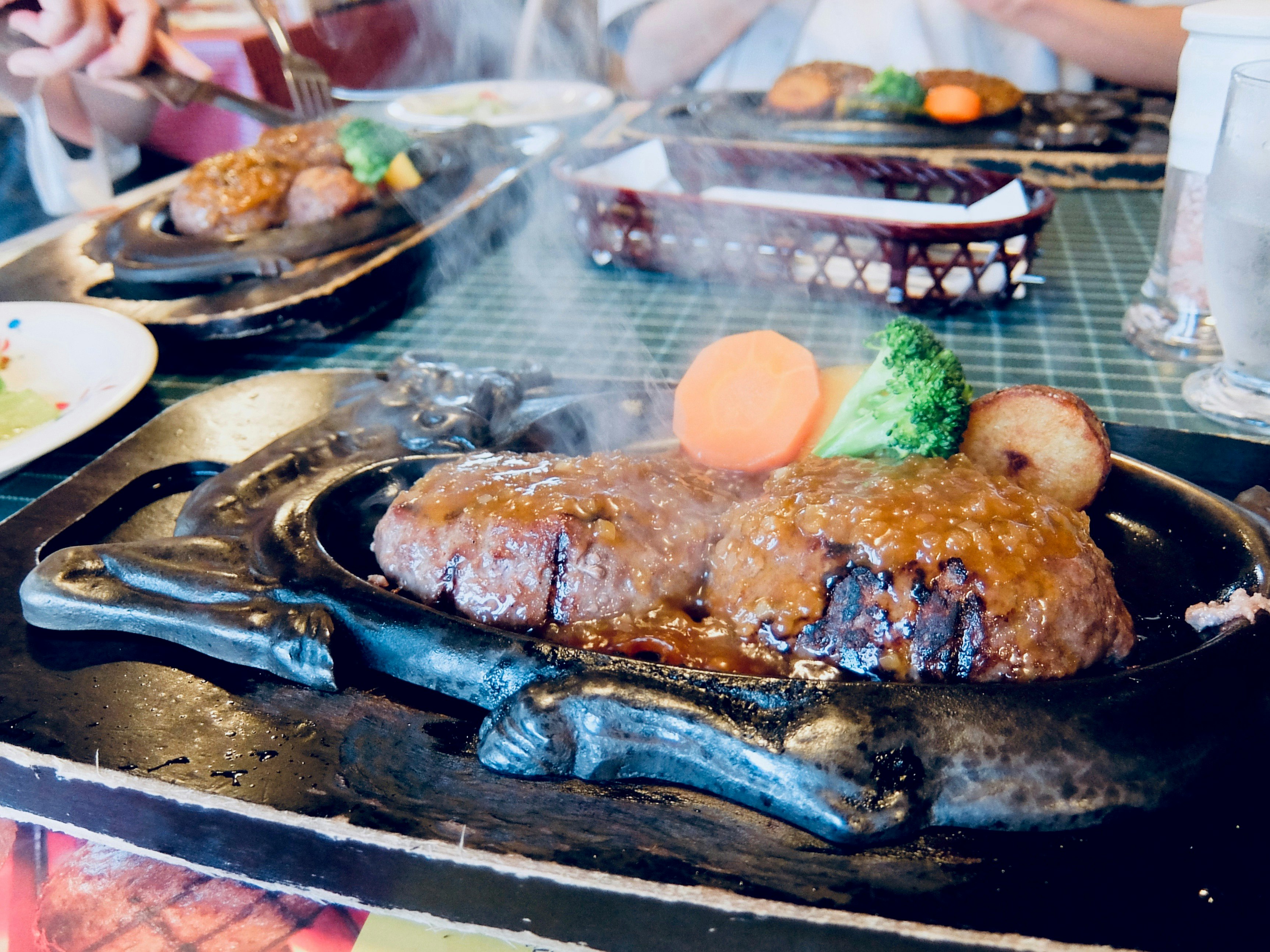 铁板上滋滋作响的烤肉和配菜