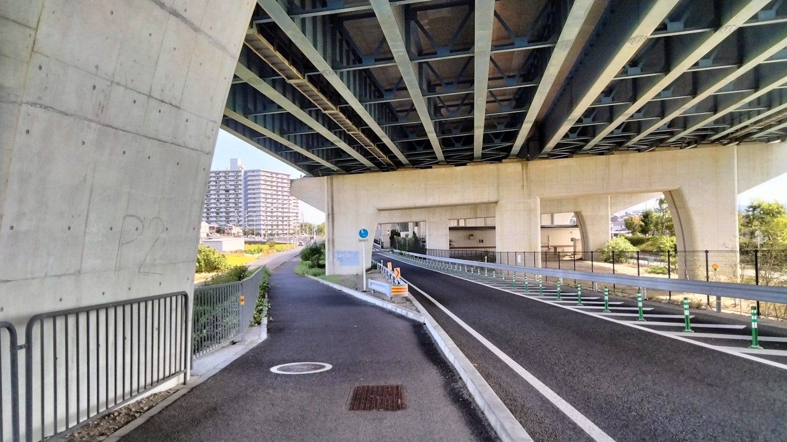 Eine Ansicht einer Straße unter einer erhöhten Struktur mit Betonträgern