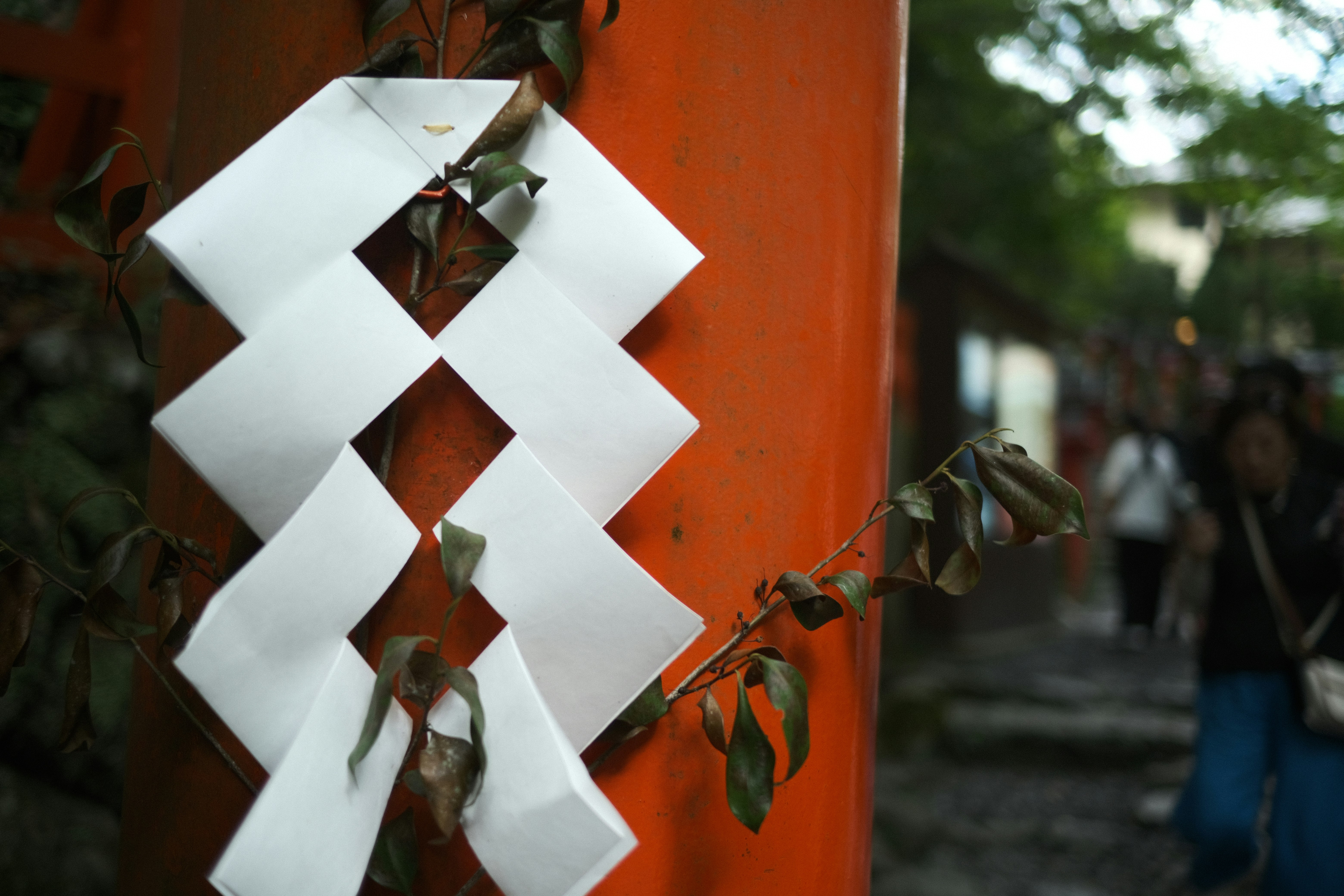 Cinta blanca atada a una pared naranja con personas al fondo