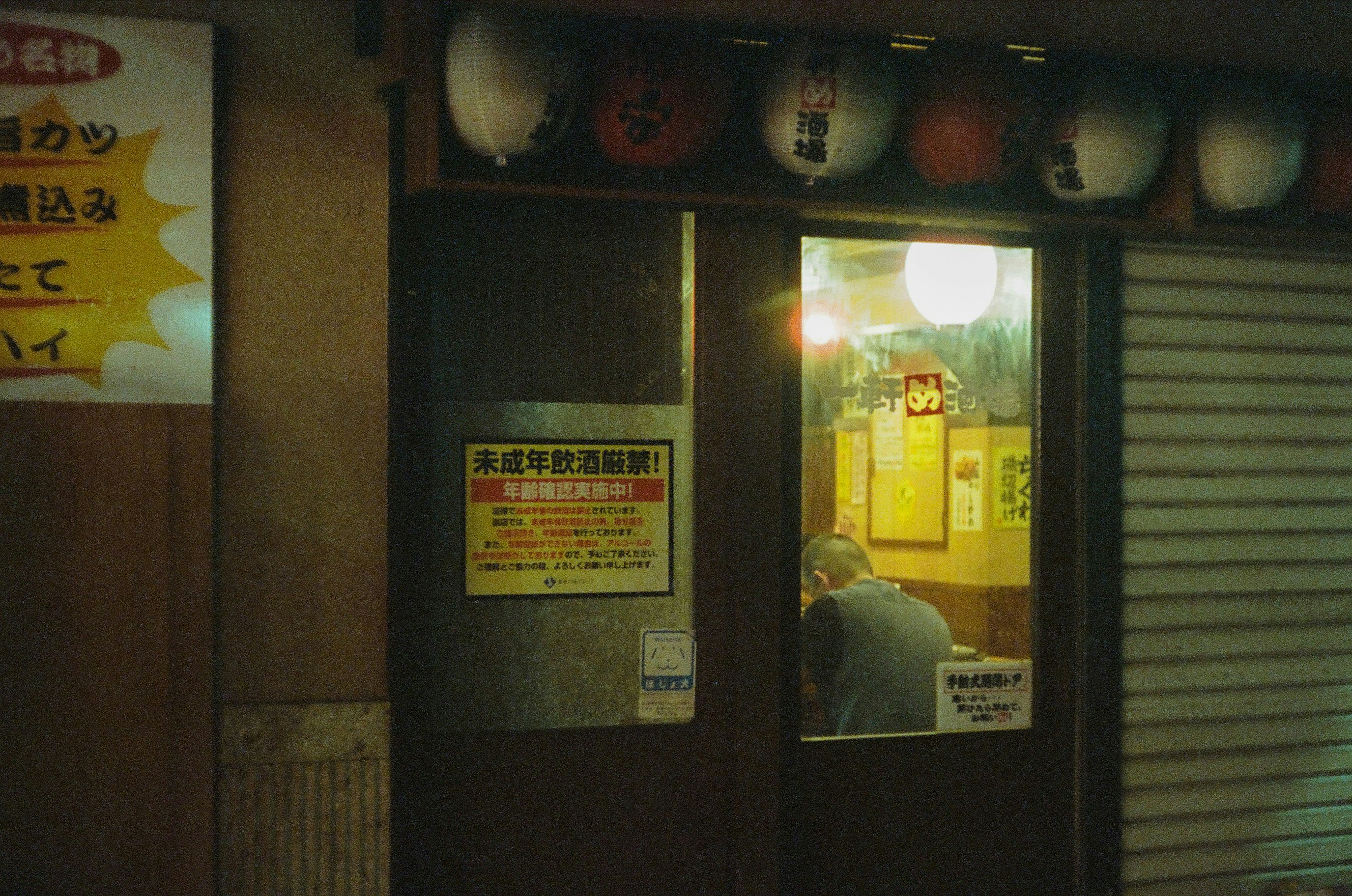 夜晚店铺入口的招牌与卷帘门