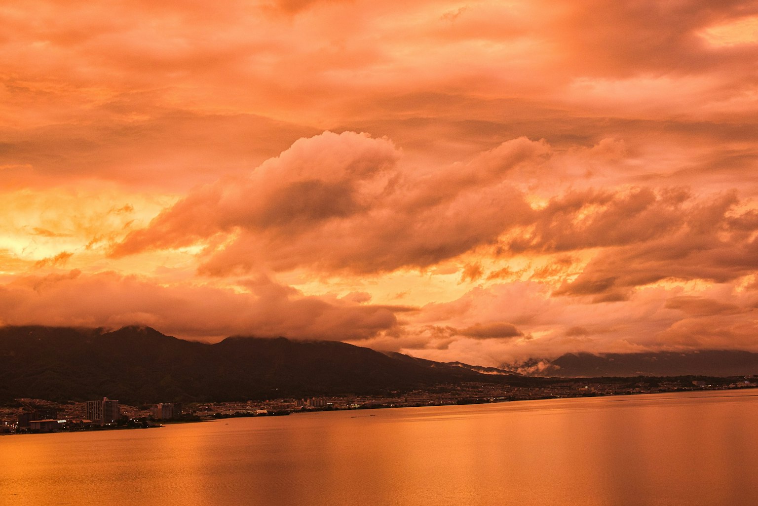 Vue panoramique d'un coucher de soleil orange se reflétant sur l'eau