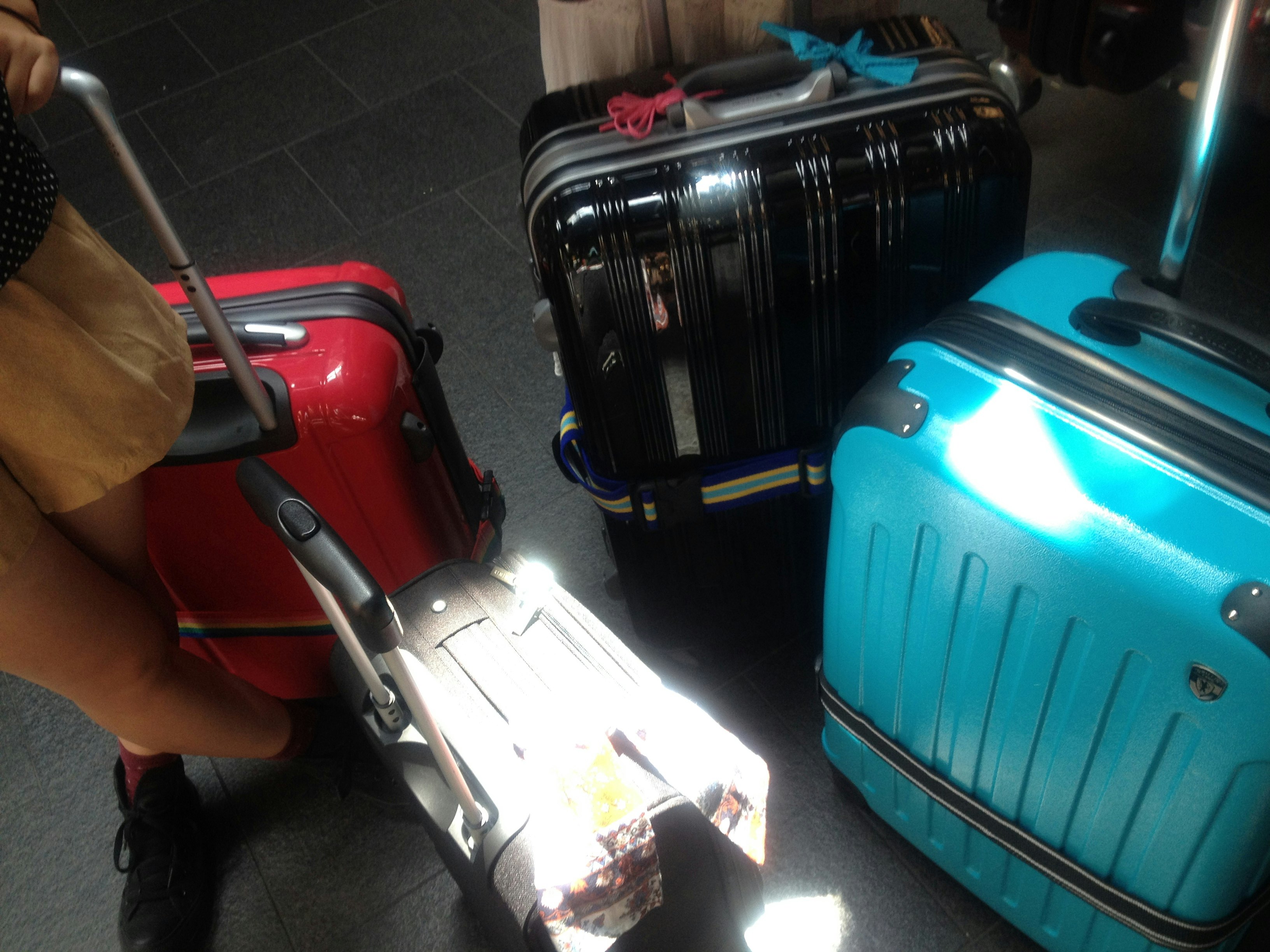 suitcases beside a person carrying luggage in a station corridor
