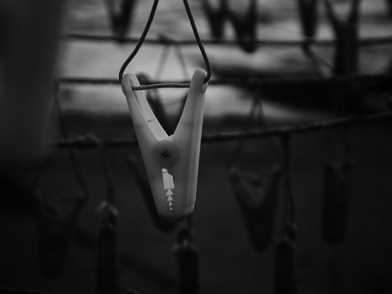 Black and white image of a clothes peg hanging on a line