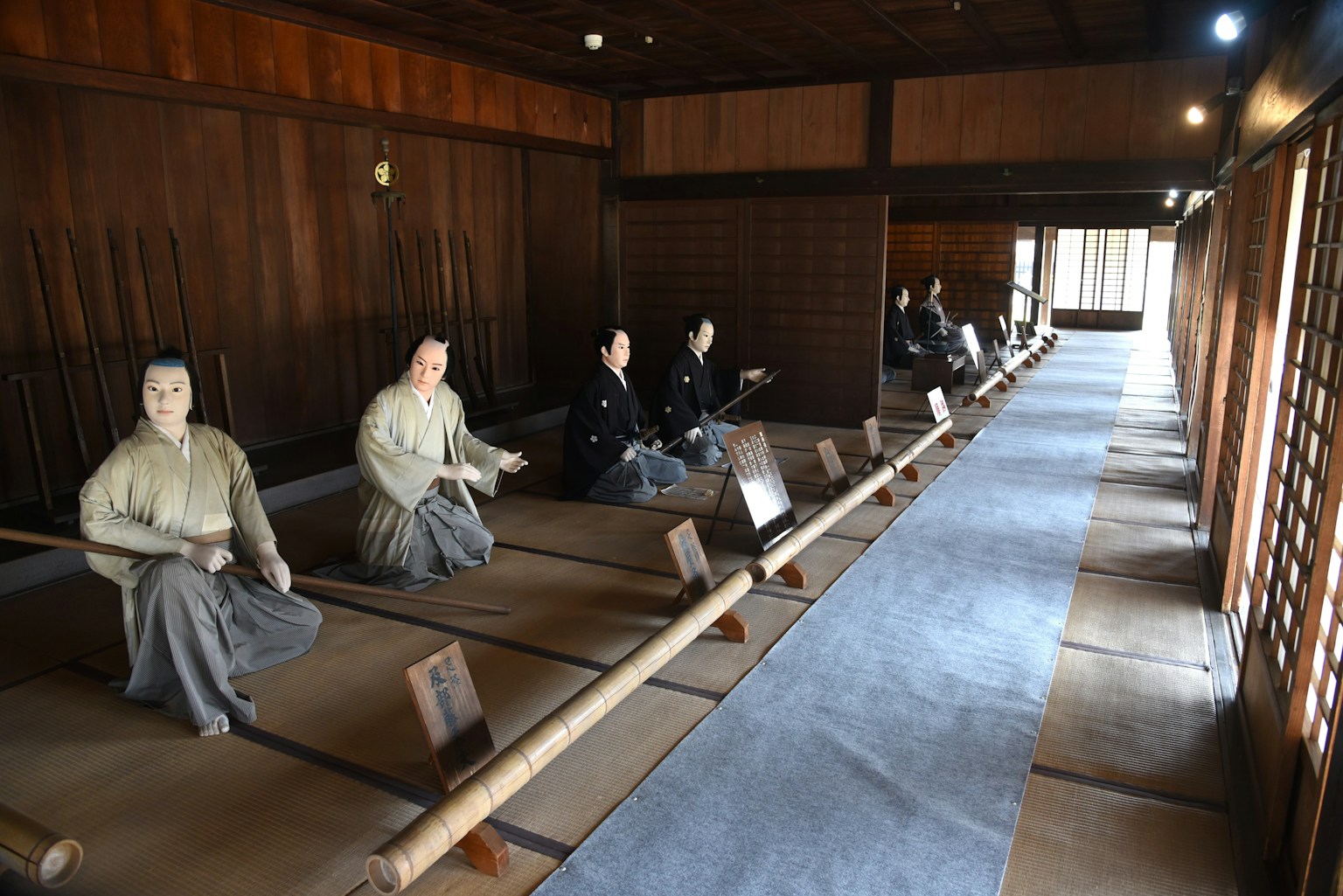 Innenraum eines traditionellen japanischen Zimmers mit sitzenden Figuren und Holzwänden