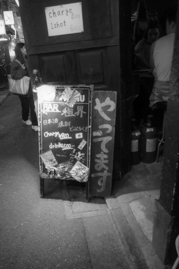 panneaux et étalage de produits devant une boutique dans une ruelle