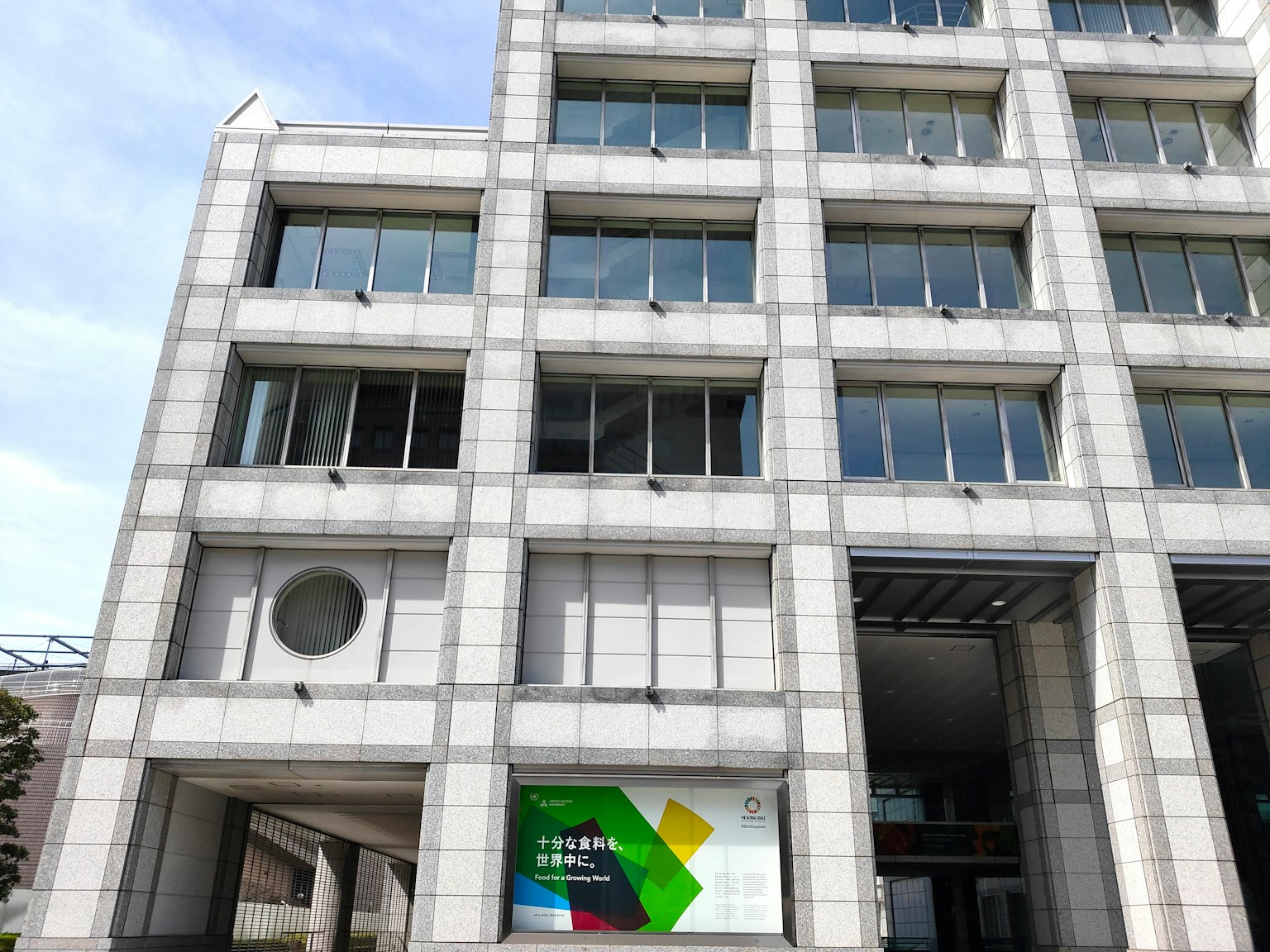 Bâtiment moderne à l'extérieur blanc avec une signalétique colorée et des fenêtres carrées