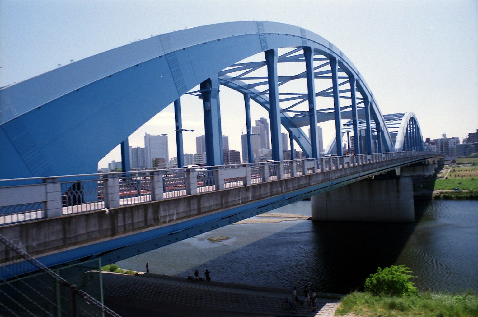 สะพานโค้งสีน้ำเงินพร้อมทิวทัศน์เมืองในพื้นหลัง