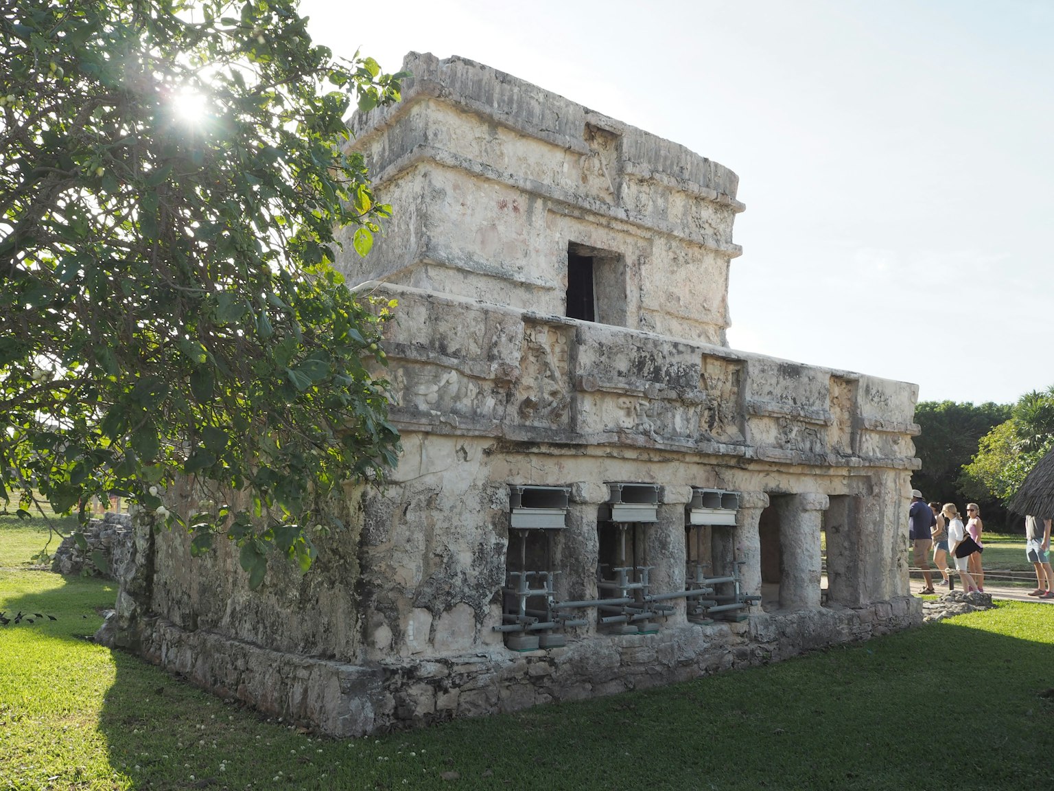 古代玛雅文明的小石建筑侧面，周围环绕着绿色植物