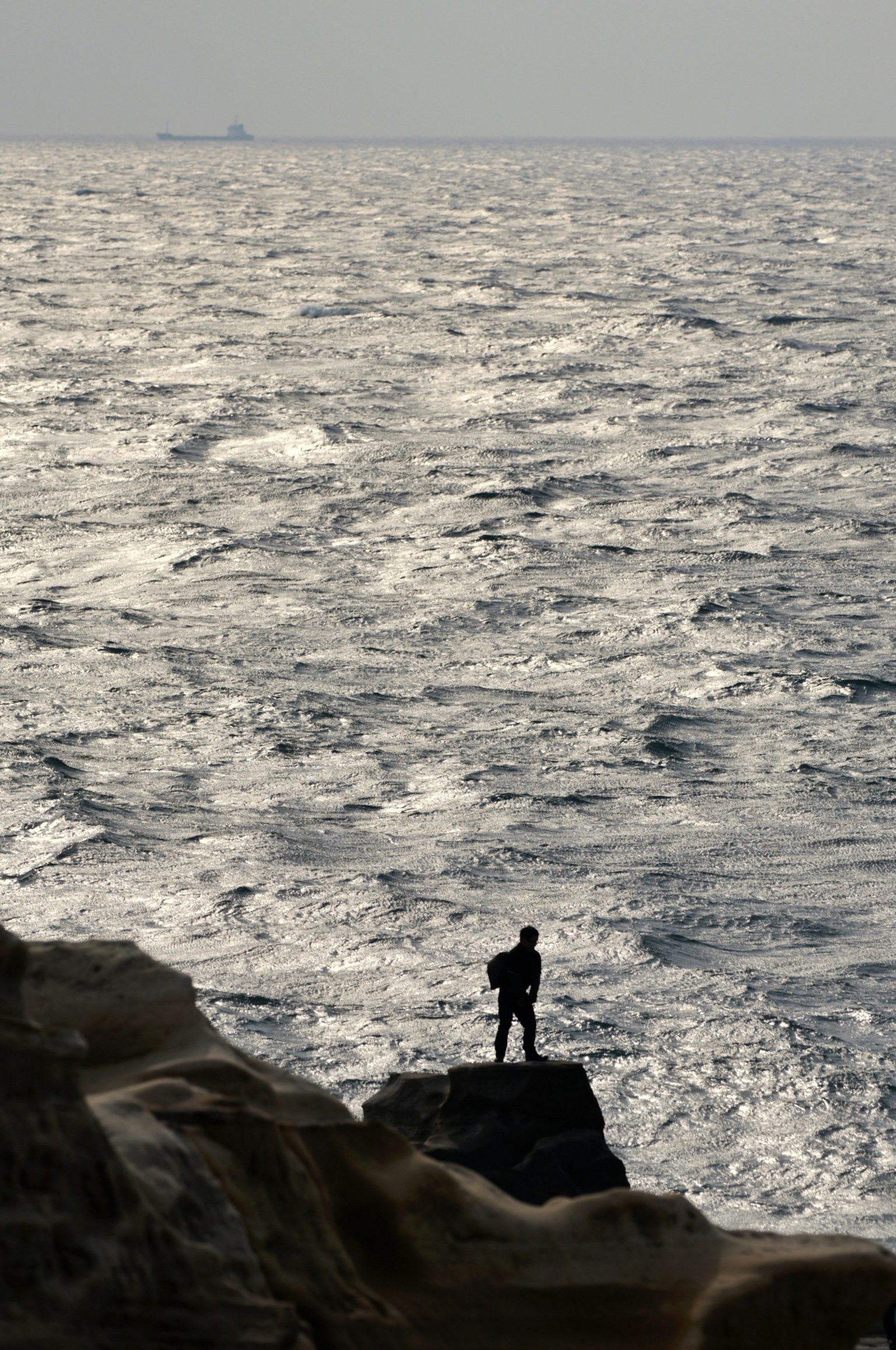 Silhouette di un uomo in piedi contro l'oceano