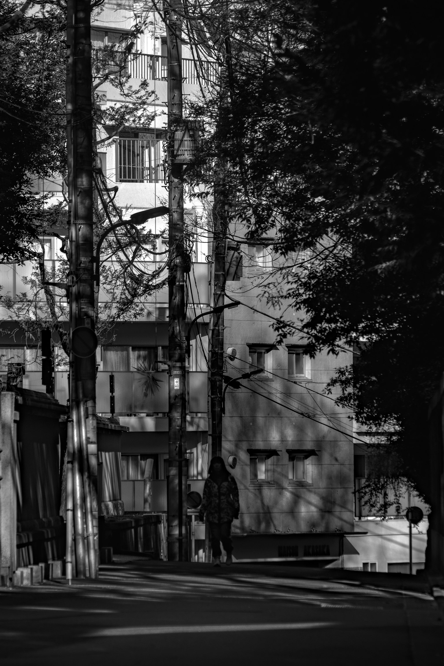Escena urbana en blanco y negro con una persona y sombras