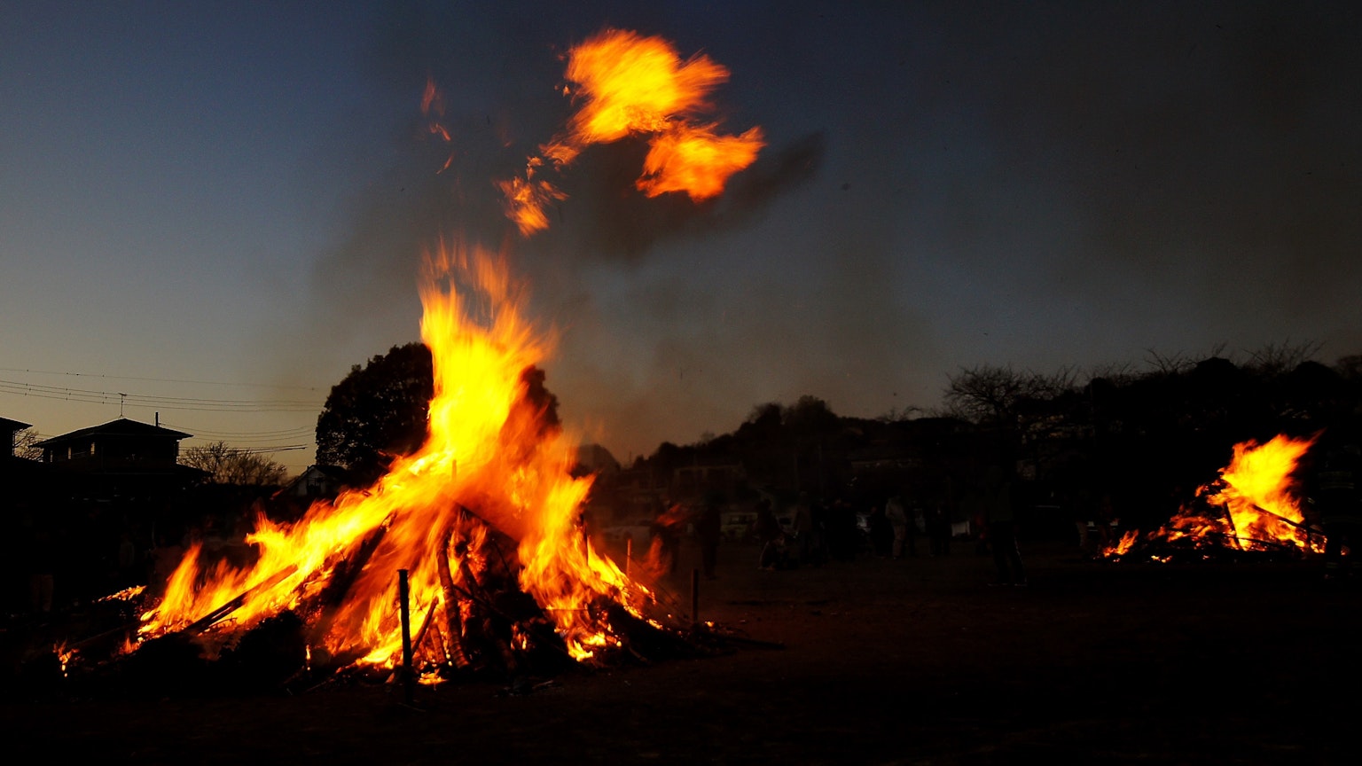 Großes Lagerfeuer brennt in der Dämmerung mit Flammen und Rauch