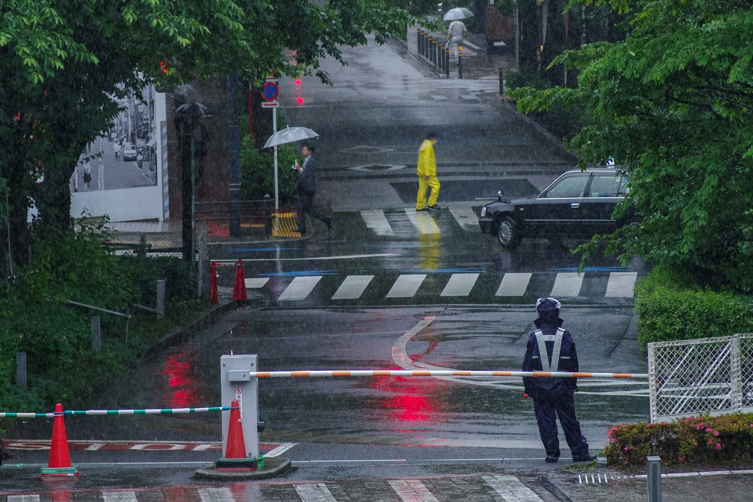 雨中行走的穿着黄色雨衣的人在街道场景