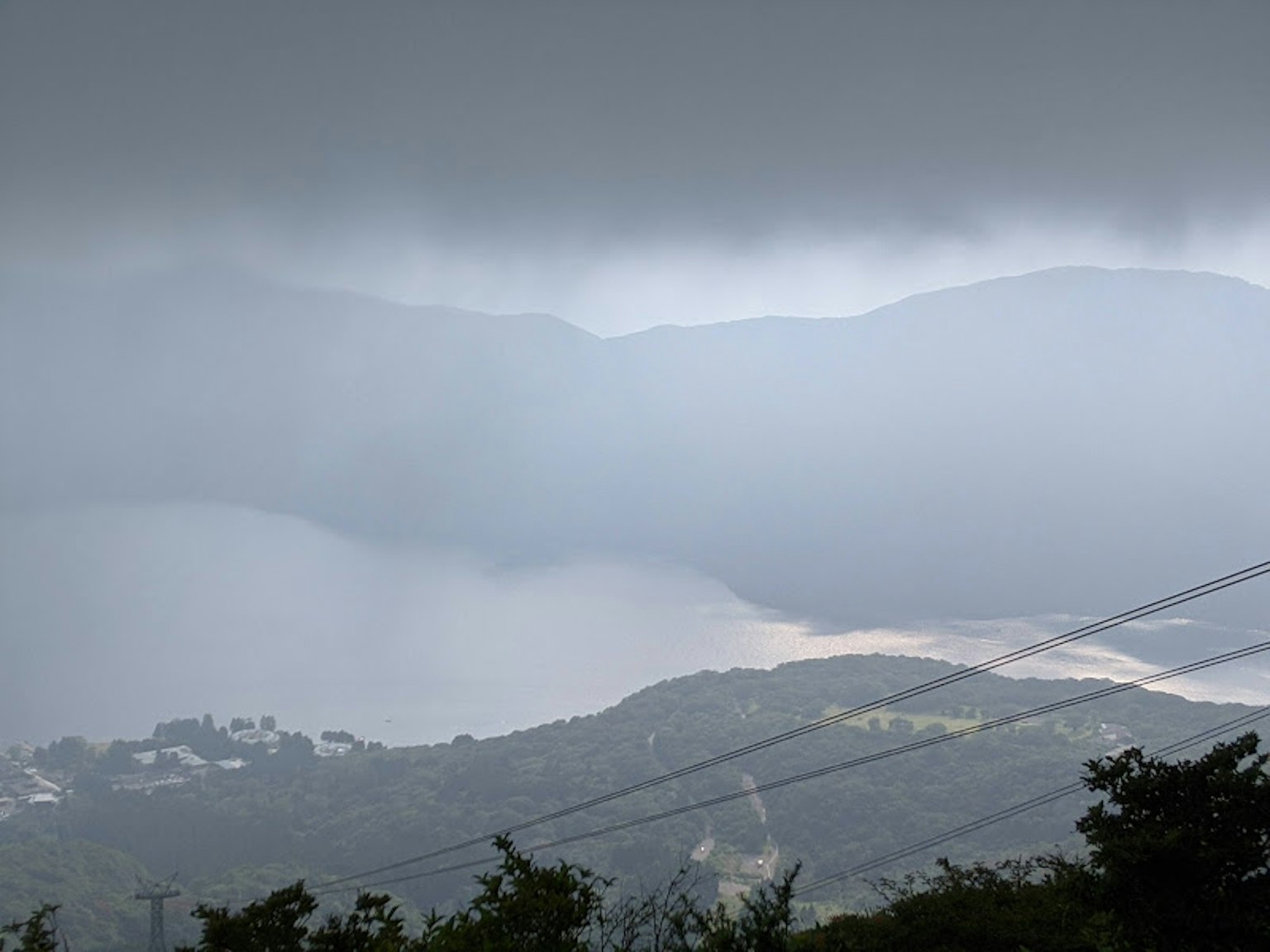 Montagne nebbiose con una superficie d'acqua calma