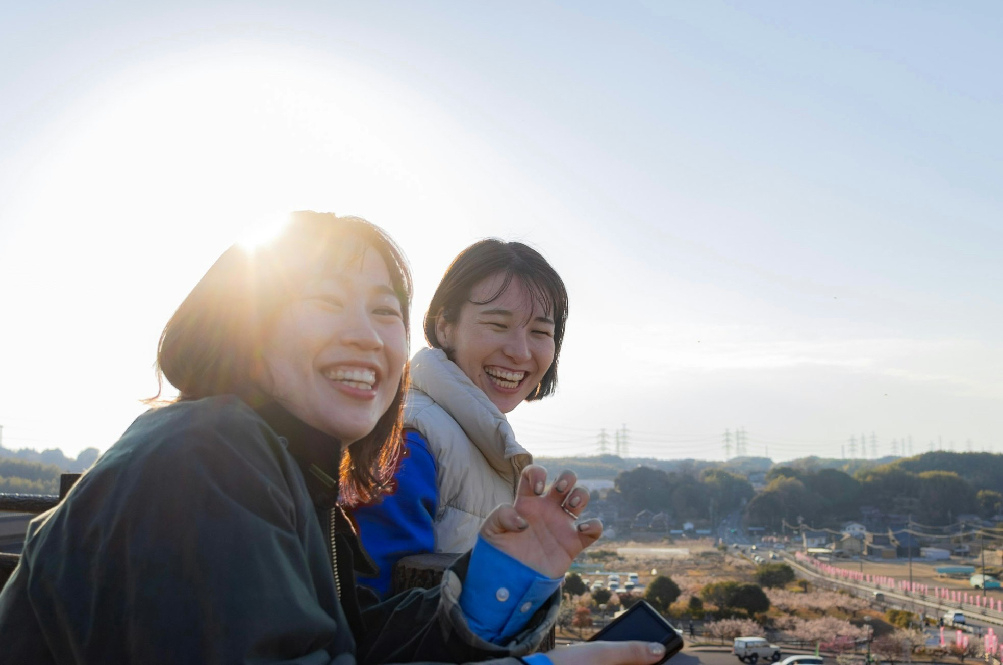 海辺の景色を見ながら笑う友人たち