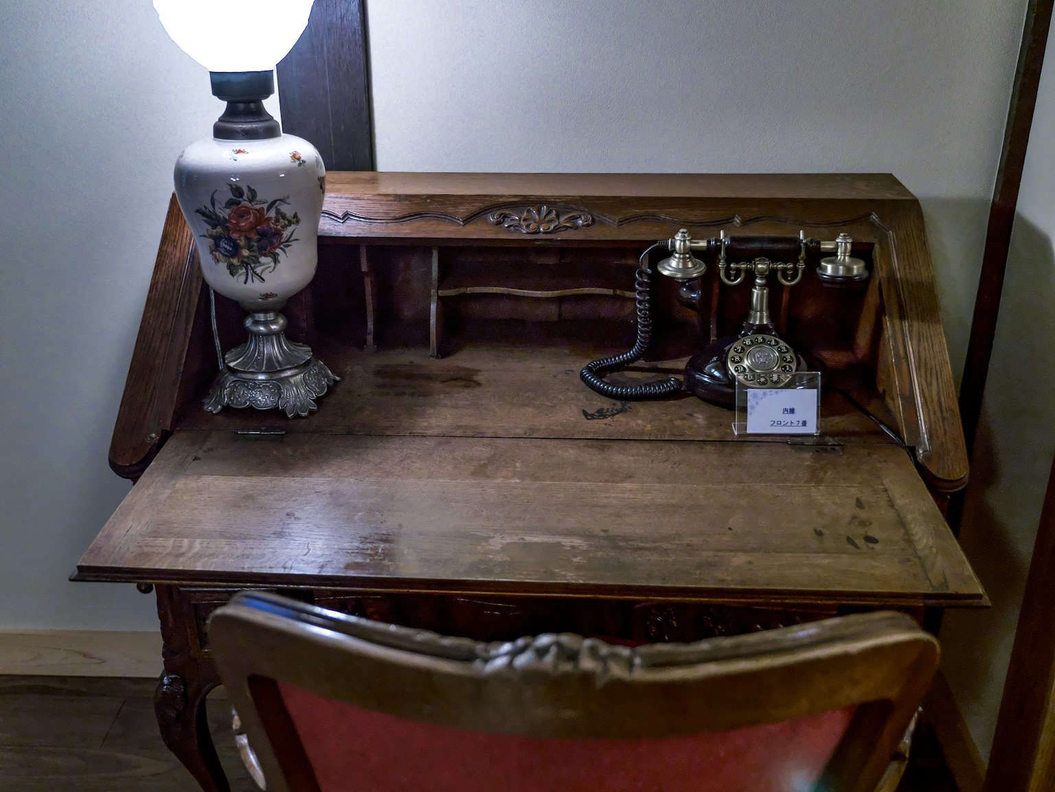 Meja antik dengan telepon vintage dan lampu di sebuah ruangan