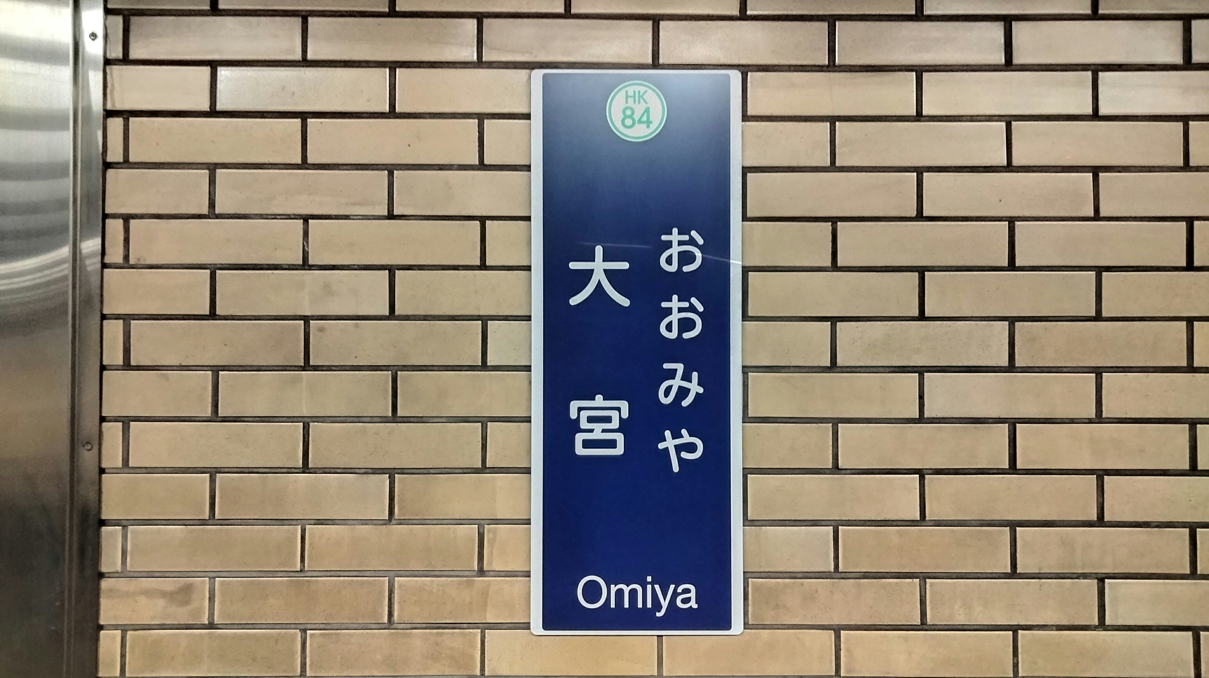磚牆上的藍色直式招牌（大宮/Omiyа）