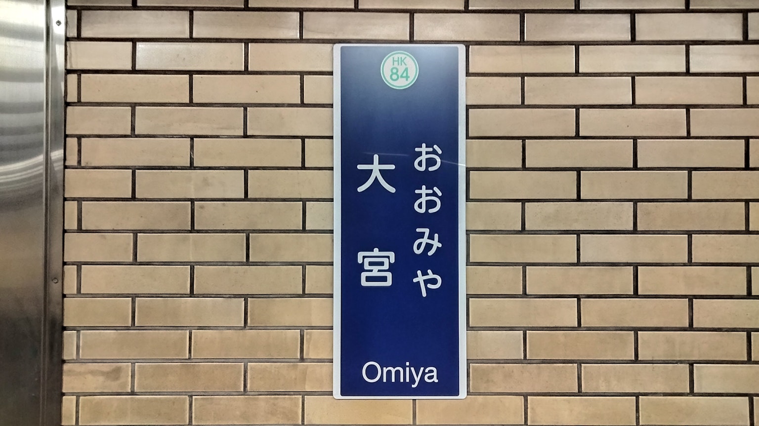 Biển chỉ dẫn ga Omiya trên tường gạch