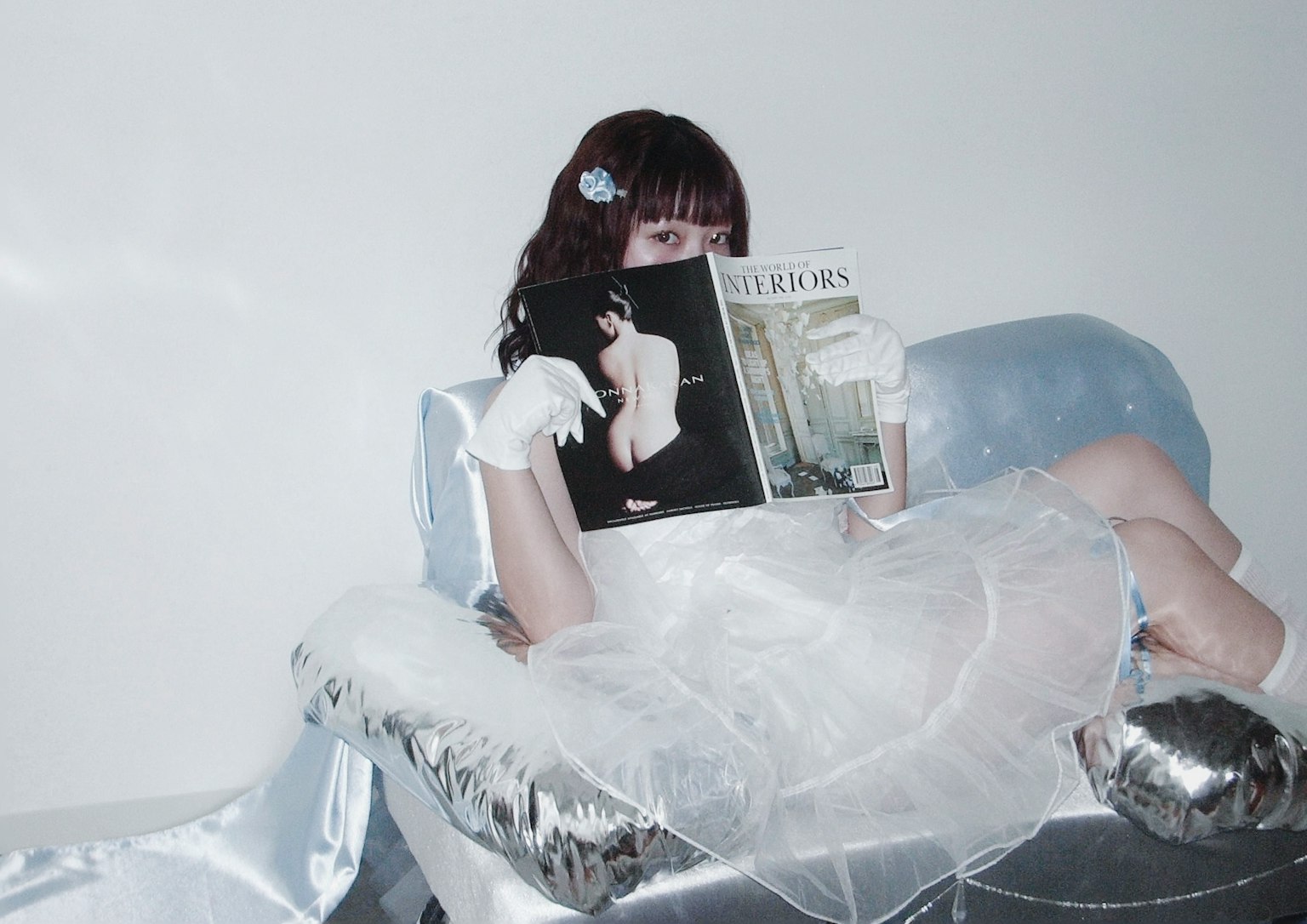 Woman in a white dress holding a magazine