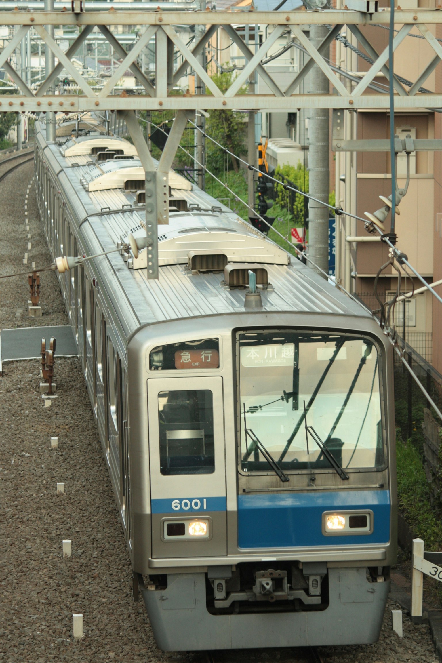 Train avec des rayures bleues sur les rails en approche d'une station
