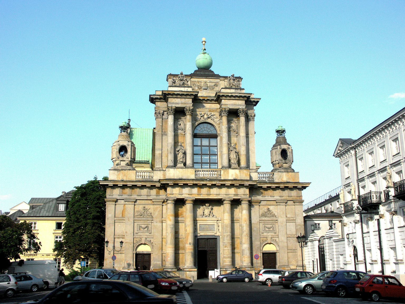 Façade d'un bâtiment historique, ciel bleu, dôme vert, décorations sculptées