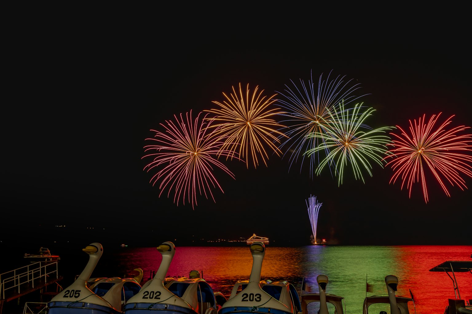 夜空中綻放著五彩繽紛煙花的海灘景象
