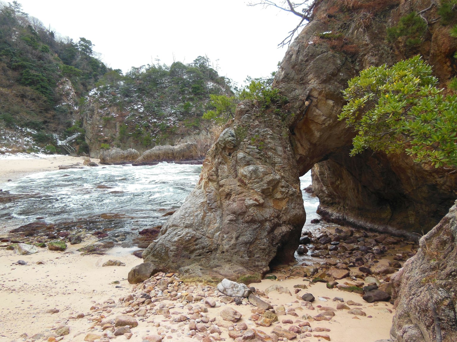 Arc rocheux côtier avec plage de sable et vagues