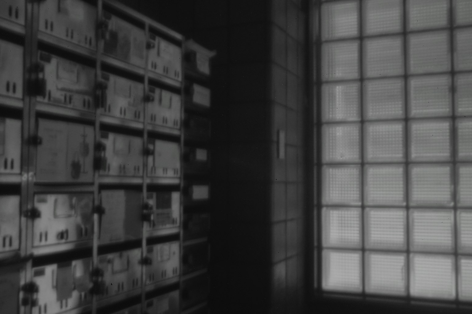 Scene featuring lockers in a dark room with a glass window