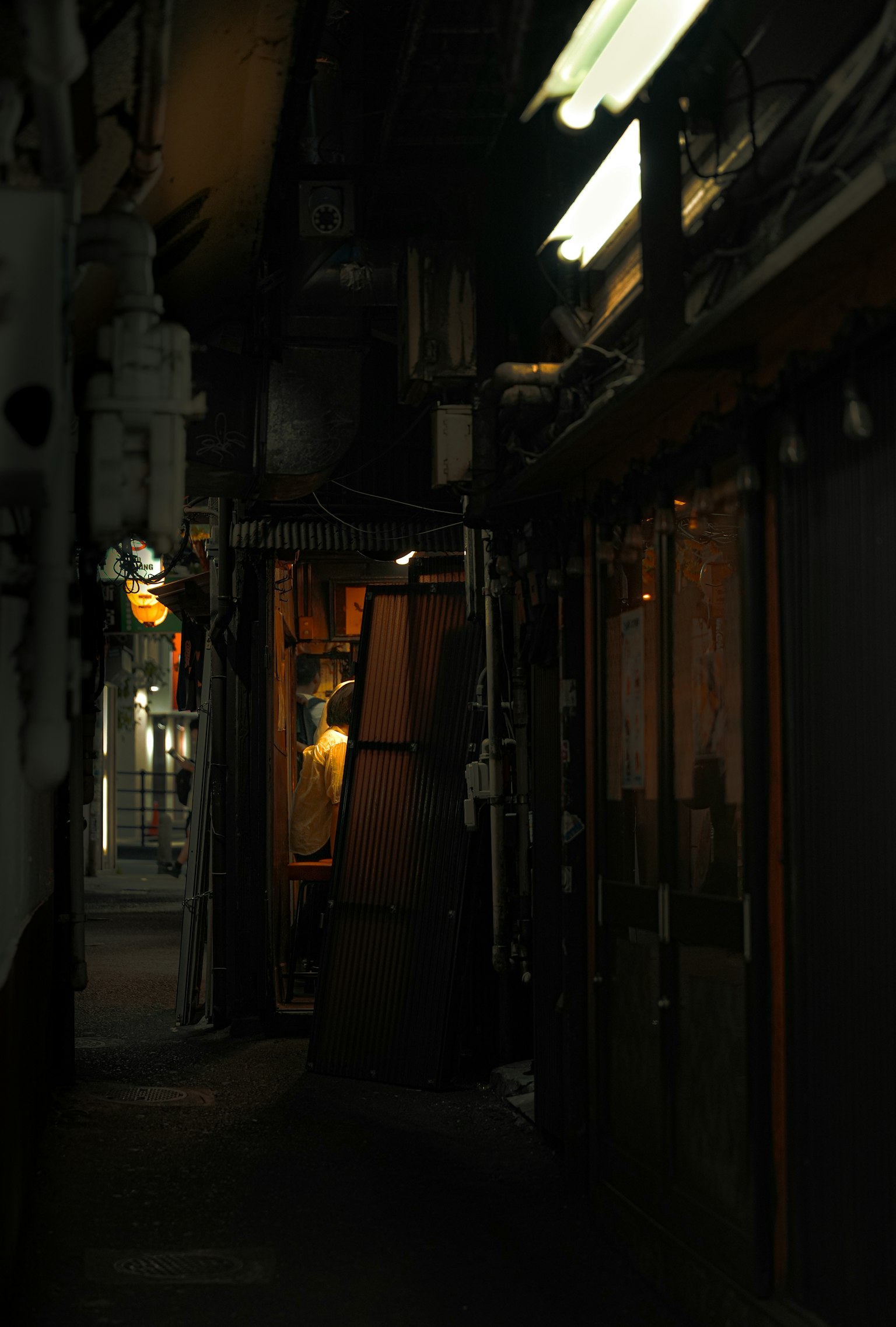 Gang yang redup dengan lampu toko kecil terlihat