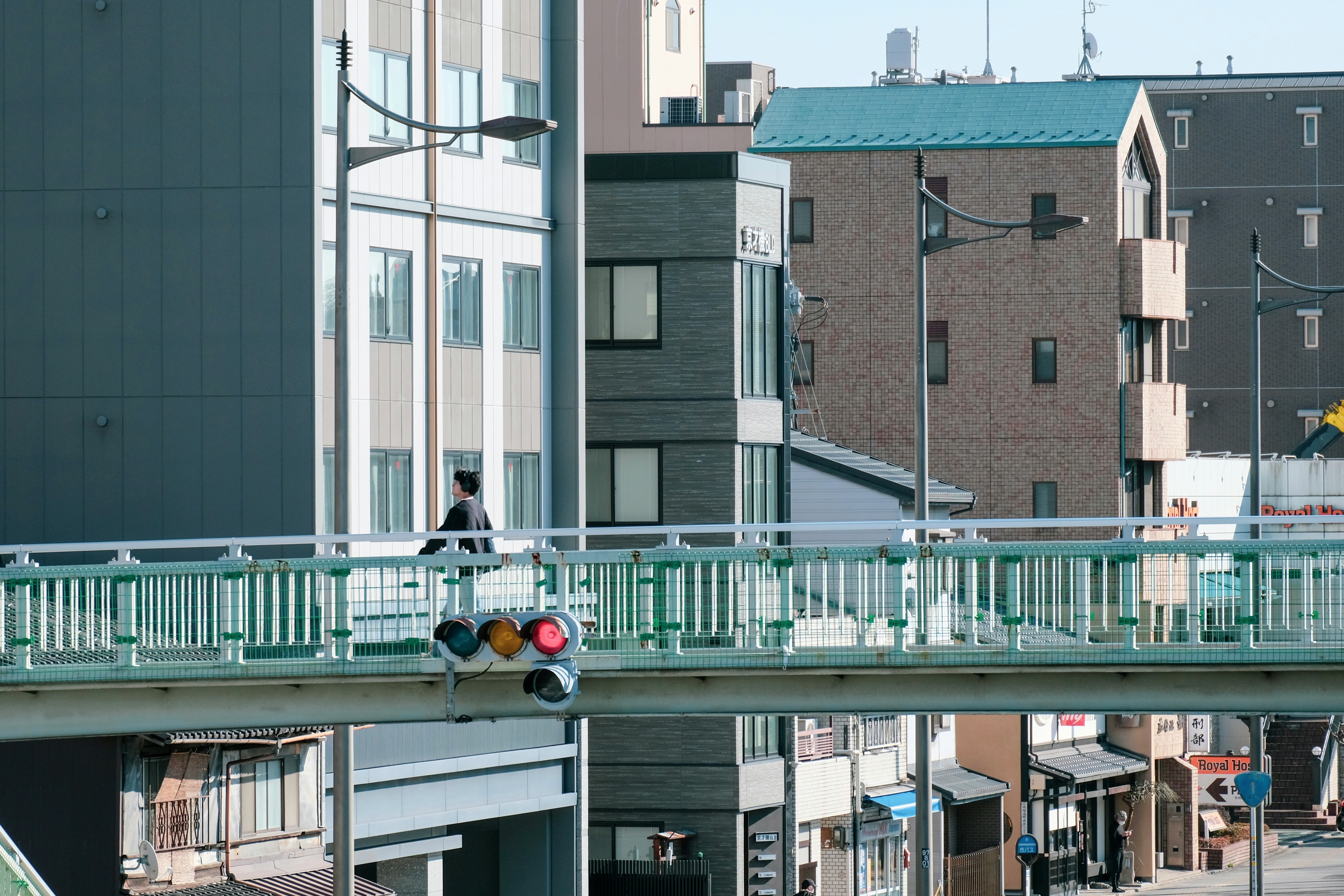 歩道橋のある都市の街並みと信号機