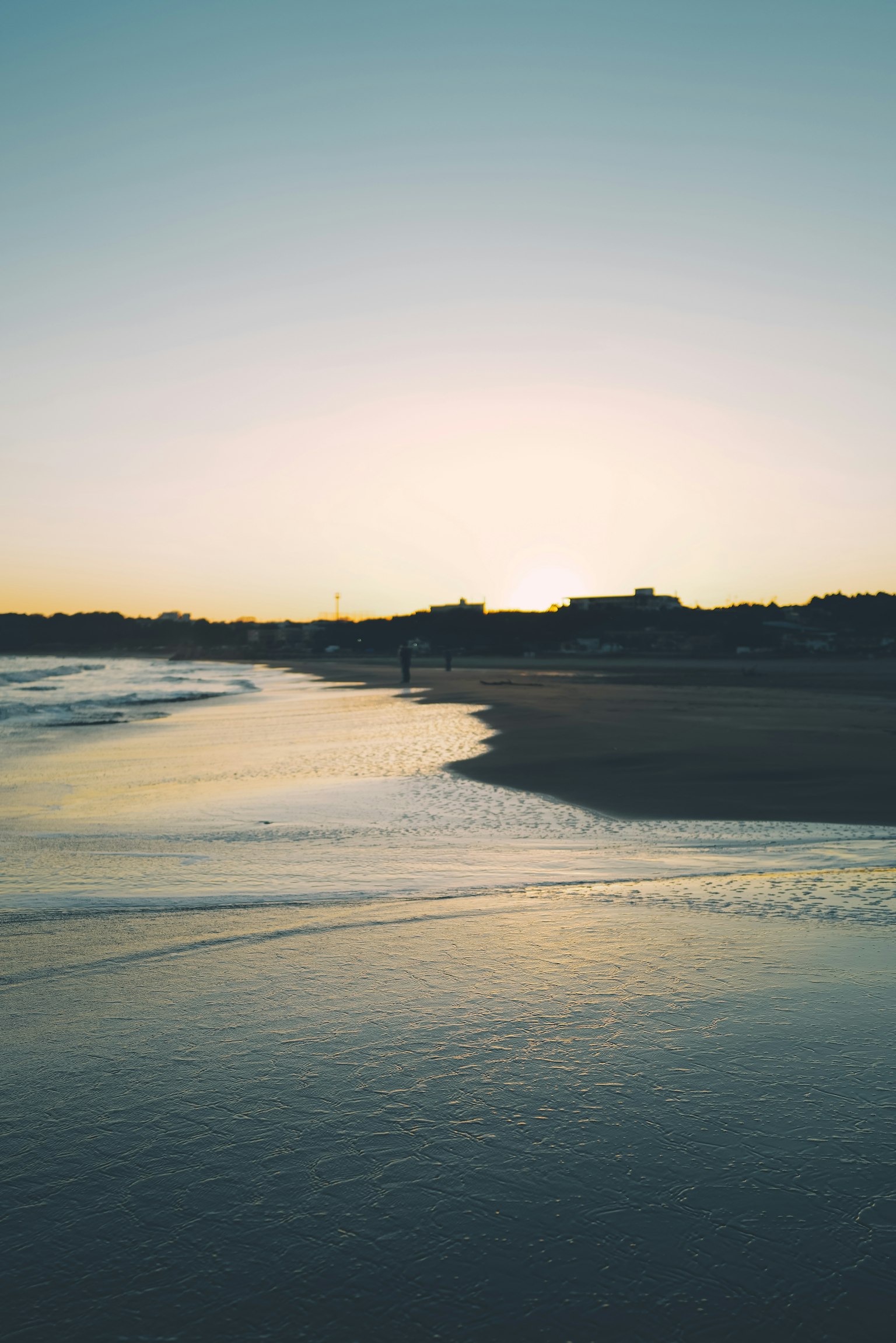Ruhiger Strand bei Sonnenuntergang mit sanften Wellen