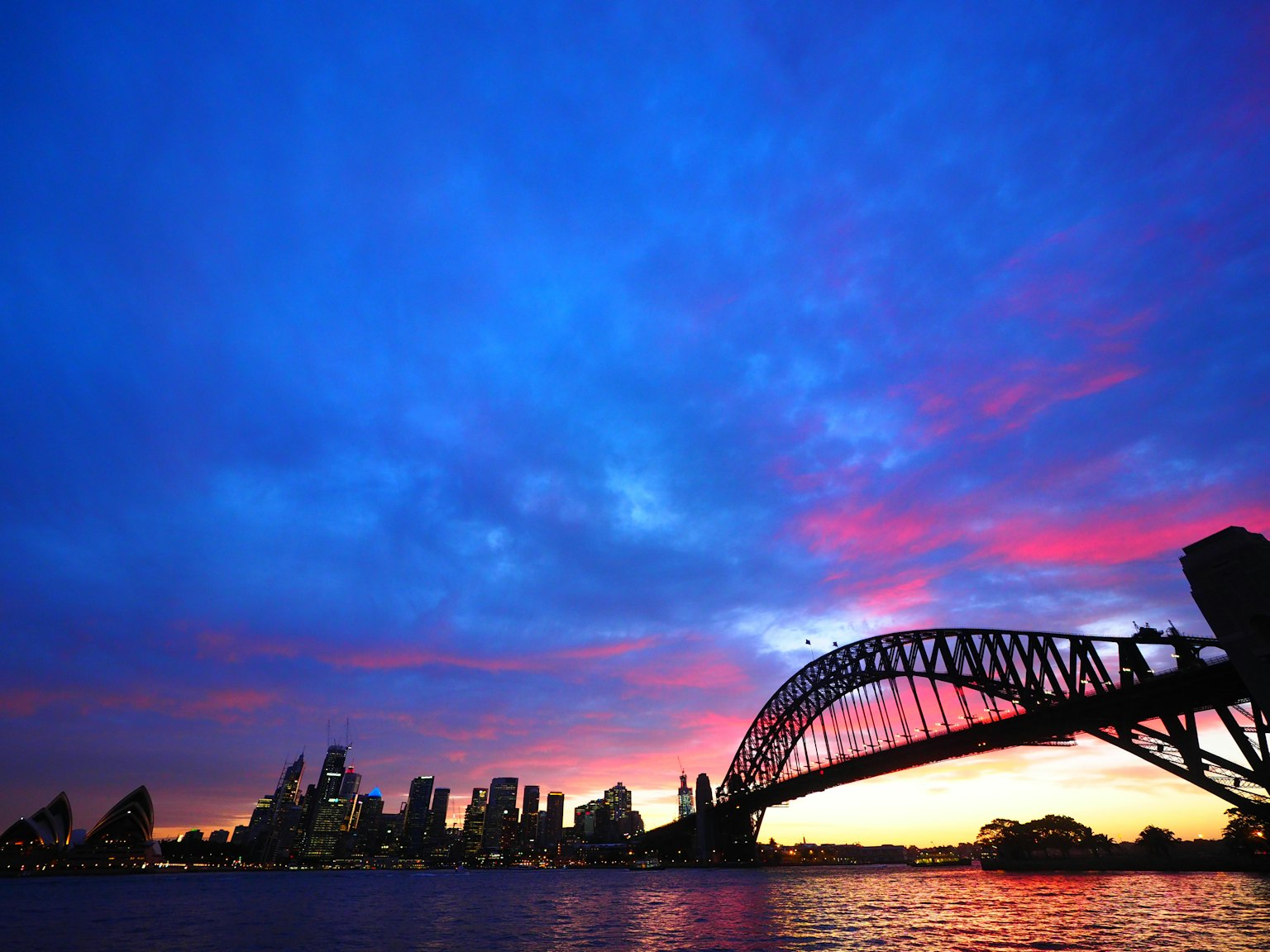 Bầu trời hoàng hôn đẹp với bóng silhouette của Nhà hát Opera Sydney và đường chân trời