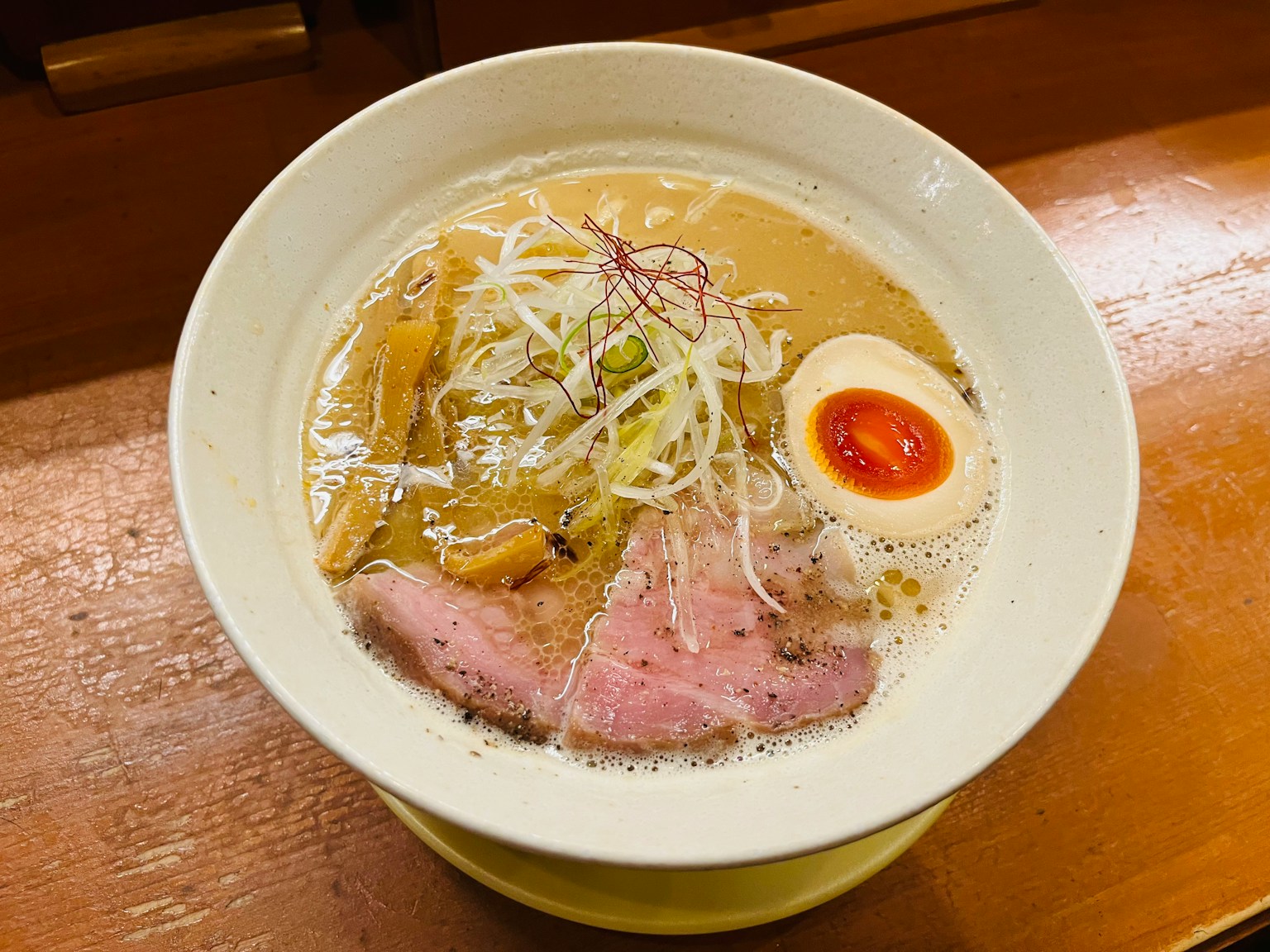 Ramen bowl with creamy broth topped with sliced pork and soft-boiled egg