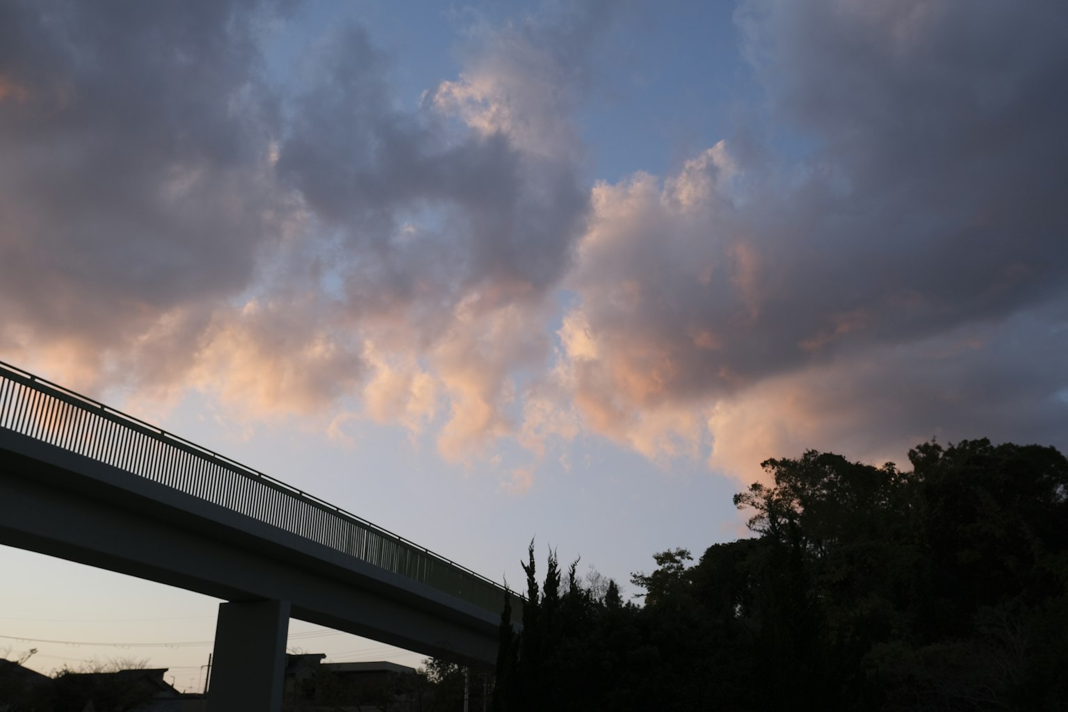 高架橋的輪廓與充滿雲彩的日落天空相映襯