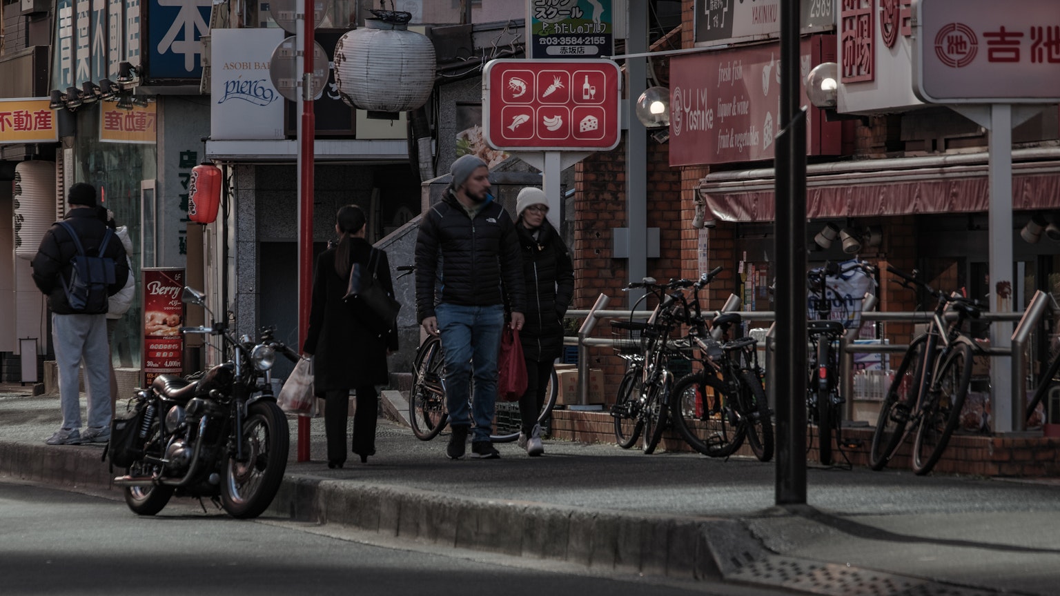 城市街道上站着的人和一辆摩托车