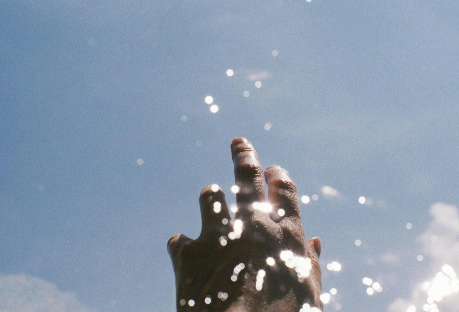 面向天空举起手的人的剪影
