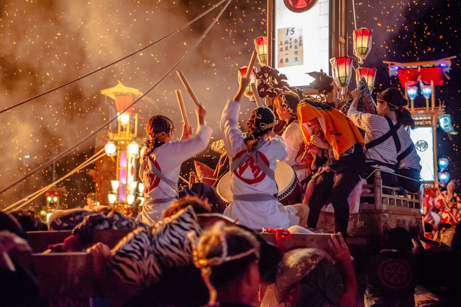 Peserta festival bermain drum dalam suasana malam yang hidup dengan lentera berwarna-warni