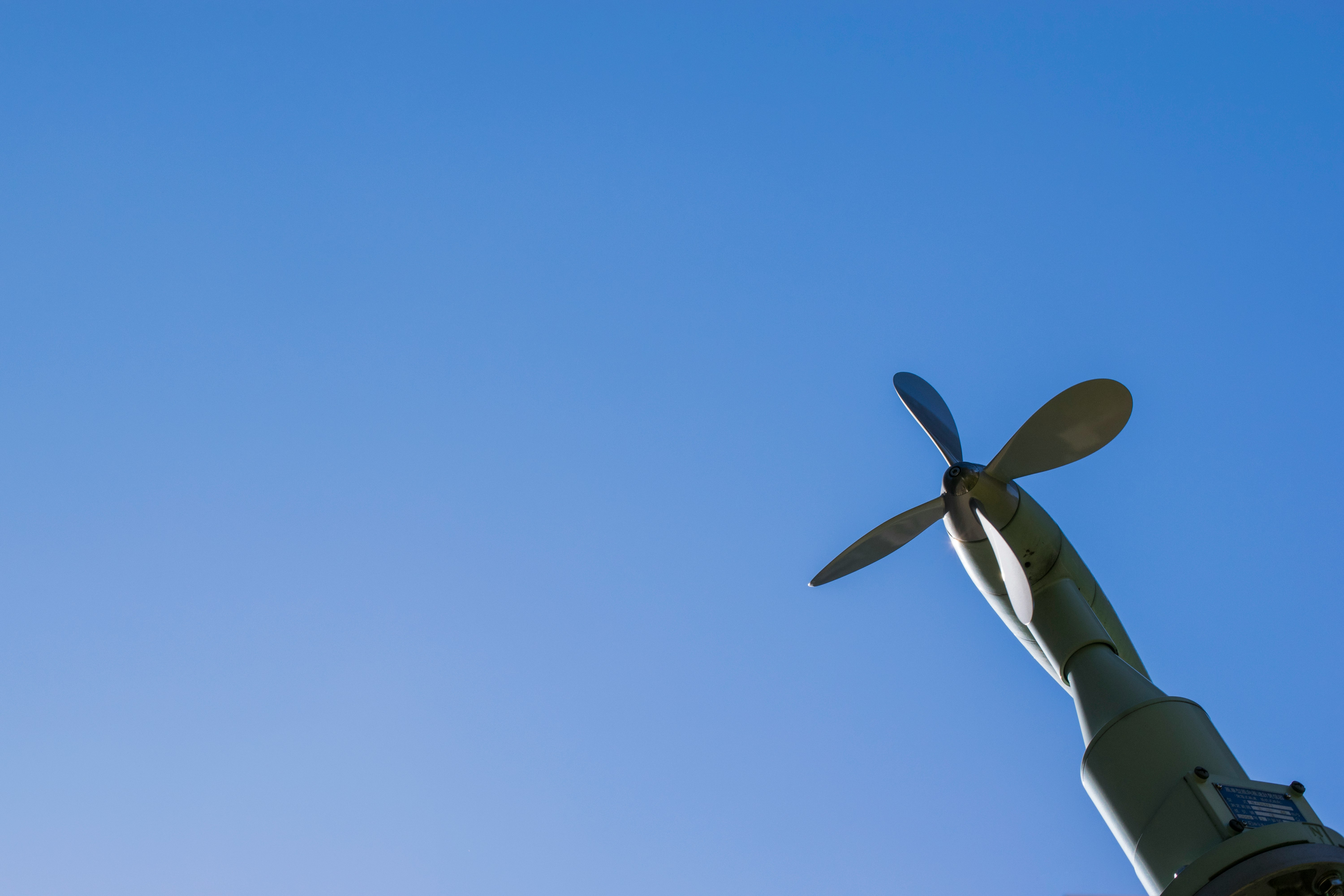 青空の下にあるプロペラのある機器の部分