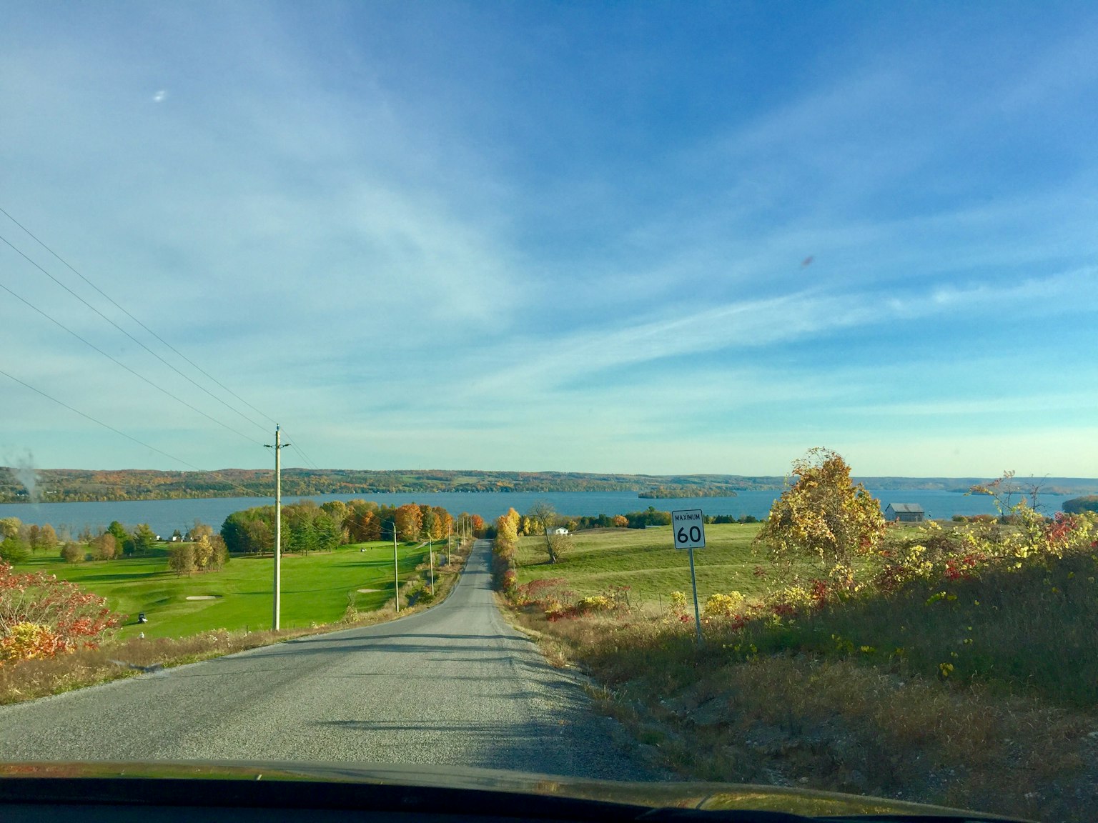 Landstraße mit Blick auf einen See und blauen Himmel